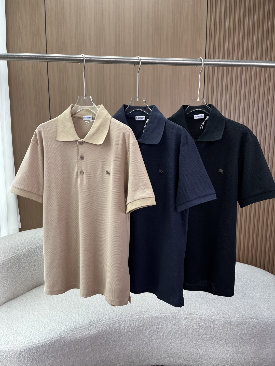 NO:899987,Burberry Classic Knight Logo Business Casual Polo Shirt. The brand gene is a British luxury brand founded in 1856. With windbreaker, plaid and Equestrian Knight Device as its core symbols, it is the representative of British style. The design language abandons the eye-catching large plaid and uses mini embroidered knight logo instead, hiding the brand recognition in the details, which is more in line with the modern 'minimalist and light luxury' dressing trend. 2. Fabric and craft details  The main fabric is cotton, using beaded mesh weaving method, which is breathable and sweat-wicking. It will not make you sweaty when wearing it in summer, while maintaining a crisp fit. The auxiliary material components of the collar/cuff ribs are 98 cotton + 2 spandex. The addition of spandex ensures elasticity and is not easy to loose and deform after long-term wear. Highlights of the process: The notch lapel design is wider and neater than the traditional Polo collar, visually modifying the neck line, making it more mature and stable.  The classic design of the three-button placket can be adjusted to suit different occasions. The mini war horse metal logo on the left chest of the same-color knight mark is the same color as the body, low-key and unobtrusive. It is the 'invisible logo' style that Burberry has mainly promoted in recent years. 3. Color matching and version adaptation The color scheme has three basic colors of navy blue, classic black and khaki. Navy blue has the strongest business sense, looks white and calm, and is suitable for workplace commuting.  Black is versatile and has a sense of casualness and formality. Khaki is gentle and retro, making it more refreshing for spring and summer wear, suitable for leisure vacations. The Regular Fit version is neither tight nor too loose, suitable for most body types, and can be worn alone or as an inner layer. 4. Wearing scenarios: Pairing with trousers or casual trousers for business commuting and a suit jacket is the standard choice of 'Smart Casual'.  For daily casual wear, pair with jeans, overalls or shorts, with white shoes or loafers, to create a British casual style. Layer it with a knitted cardigan or windbreaker to expose the collar and hem to increase the sense of layering. 5. Washing and maintenance guide 1. Machine washable, cold water/low temperature washing is recommended, wash inside out, and mixed with clothes of the same color. 2. Hang to dry, do not tumble dry, to avoid shrinkage and deformation of the fabric caused by high temperatures. 3.  Iron at low temperature and iron on the reverse side. Do not iron the embroidery area directly at high temperature. 4. Do not bleach, do not dry clean.,,burberry,burberry,loafers,shorts,jeans,jackets & coats,business suit,19860909Burberry（巴宝莉） 经典款骑士标商务休闲Polo衫 品牌基因创立于1856年的英国奢侈品牌,以风衣、格纹和马术骑士标（Equestrian Knight Device）为核心符号,是英伦风格的代表. 设计语言摒弃了醒目的大格纹,改用迷你刺绣骑士标,将品牌辨识度藏于细节,更符合现代“极简轻奢”的穿搭趋势. 二、面料与工艺细节  主体面料棉,采用珠地网眼织法,透气排汗,夏季穿着不闷汗,同时保持挺括版型. 辅料成分领口/袖口罗纹为98棉 + 2氨纶,氨纶的加入保证了弹性,久穿不易松垮变形. 工艺亮点 平驳领设计比传统Polo领更宽、更利落,视觉上修饰颈部线条,更显成熟稳重. 三粒扣门襟经典设计,可调节开合度,适配不同场合. 同色骑士标左胸位置的迷你战马金属logo,与衣身同色,低调不张扬,是Burberry近年主推的“隐形Logo”风格. 三、配色与版型适配  配色方案藏青色、经典黑、卡其色三款基础色 藏青色商务感最强,显白且沉稳,适合职场通勤. 黑色百搭不出错,兼具休闲与正式感. 卡其色温柔复古,春夏穿着更显清爽,适合休闲度假. 版型Regular Fit（常规合身版）,不紧绷也不过于宽松,适配大多数身材,既能单穿,也可作为内搭叠穿. 四、穿搭场景 商务通勤搭配西裤或休闲裤,外搭西装外套,是“Smart Casual”的标准选择. 日常休闲搭配牛仔裤、工装裤或短裤,脚踩小白鞋或乐福鞋,打造英伦休闲风. 叠穿搭配内搭在针织开衫或风衣里,露出领口和下摆,增加层次感. 五、洗护与保养指南 1. 洗涤可机洗,建议冷水/低温洗涤,反面清洗,与同色衣物混洗. 2. 晾晒悬挂晾干,不可烘干,避免高温导致面料收缩变形. 3. 熨烫低温反面熨烫,不可高温直接熨烫刺绣部位. 4. 禁忌不可漂白,不可干洗.,,burberry,burberry,loafers,shorts,jeans,jackets & coats,business suit,,Women's clothing