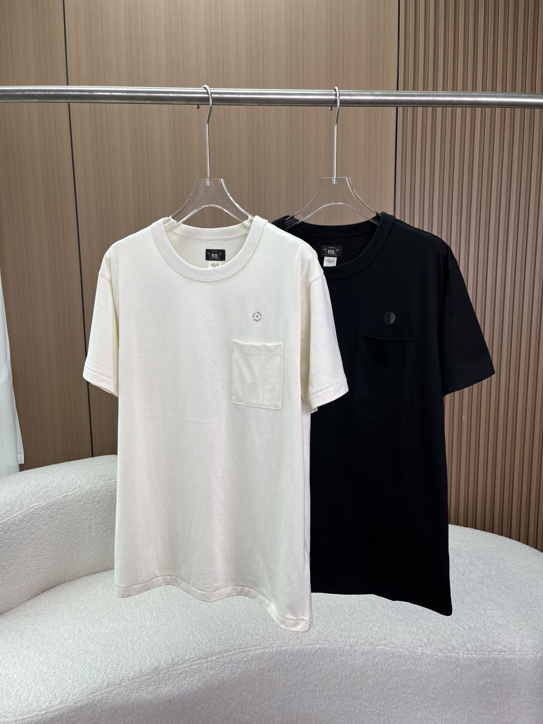 NO:808350,A box of two pieces RRL (Double RL) American retro pure cotton pocket short-sleeved T-shirt This is the RRL American retro series pure cotton pocket short-sleeved T-shirt, available in two high-end colors of black and off-white. It does not rely on exaggerated large logos, but highlights texture through texture, version and details. It is the core top to create American retro and old money style. 1. Fabric and material Core ingredient cotton (Cotton)  The high-count combed cotton is made from high-count long-staple cotton specially supplied by the brand. It has undergone multiple pre-shrunk treatments and a special enzyme washing process. It feels softer, skin-friendly and thicker than ordinary pure cotton, and has a distressed retro luster. The more you wear it, the more it wears you. The breathable and sweat-absorbent natural cotton fiber is breathable and sweat-absorbent, making it refreshing and non-sticky to wear in summer, without feeling stuffy.  Anti-pilling/resistant to fabrication Due to the high density of the fabric, it is not easy to pill or deform after long-term wear, and has excellent durability, which is the core logic of the RRL brand to 'wear it for a lifetime'. 2. Iconic design details This T-shirt interprets 'simple but not simple' to the extreme, and every detail reveals high-end retro ingenuity.  The heavy-weight ribbed crew neck uses high-weight double-needle ribs, which have been treated with retro distressing. The rib texture is clear and has good resilience. It is not easy to deform or loose after multiple washings, and perfectly supports the retro version. The red RRL retro woven label may be printed on the inside to add texture and detail.  The American-style slightly loose fit adopts a straight micro-taper/dropped shoulder cut. The fit is more three-dimensional than ordinary T-shirts, covering the flesh and making you look slimmer. It is neither tight nor draggy, and perfectly fits the Asian male figure, creating a casual and relaxed American retro feel.  The retro distressed craft fabric has been treated with special enzyme water/stone washing, giving it a natural distressed texture and faded color. The black model is deep and textured, while the off-white model is warm and creamy, different from the pale whiteness of ordinary white T-shirts, and has a strong sense of luxury.  Detailed craftsmanship: The cuffs and hem adopt double-needle hemming technology, and the stitching is straight and neat without excess thread; the pockets are sewn flat and fit the body, reflecting the ultimate quality control of American manufacturing.,, T-shirt, tees, t-shirt,19860909一盒两件装 RRL (Double RL) 美式复古纯棉口袋短袖T恤 这是RRL 美式复古系列 纯棉口袋短袖T恤,提供黑色、米白2种高级配色.它不依赖夸张的大Logo,而是通过肌理感、版型和细节来彰显质感,是打造美式复古、老钱风的核心上装. 1. 面料与材质 核心成分棉（ Cotton） 高支精梳棉选用品牌特供的高支数长绒棉,经过多次预缩水处理与特殊酵素水洗工艺.手感比普通纯棉更加软糯、亲肤且有厚度,自带做旧的复古光泽,越穿越软,越穿越有味道. 透气吸汗天然棉纤维透气吸汗,夏季穿着清爽不黏身,无闷热感. 抗起球/耐造因为面料密度高,长期穿着不易起球、不易变形,具备极佳的耐用性,是RRL品牌「穿一辈子」的核心逻辑. 2. 标志性设计细节 这件T恤将「简约而不简单」诠释到了极致,每一处细节都透着高端复古的匠心 重磅罗纹圆领领口采用高克重双针罗纹,经过复古做旧处理,罗纹纹理清晰,回弹性好.多次洗涤后不易变形、不松垮,完美支撑起复古的版型,内侧可能印有红色的RRL复古织标,增加细节质感. 美式微宽松版型采用直筒微锥/落肩剪裁,版型比普通T恤更有立体感,遮肉显瘦.既不紧绷,又不拖沓,完美适配了亚洲男性身形,打造随性松弛的美式复古感. 复古做旧工艺面料经过特殊的酵素水洗/石洗处理,自带自然的做旧纹理和落色感.黑色款深邃有质感,米白色款温润奶糯,区别于普通白T的惨白,高级感极强. 细节工艺袖口、下摆采用双针锁边工艺,走线笔直工整,无多余线头；口袋缝制平整,贴合衣身,体现了美国制造的极致品控.,,T-shirt,tees，t-shirt,,Women's clothing
