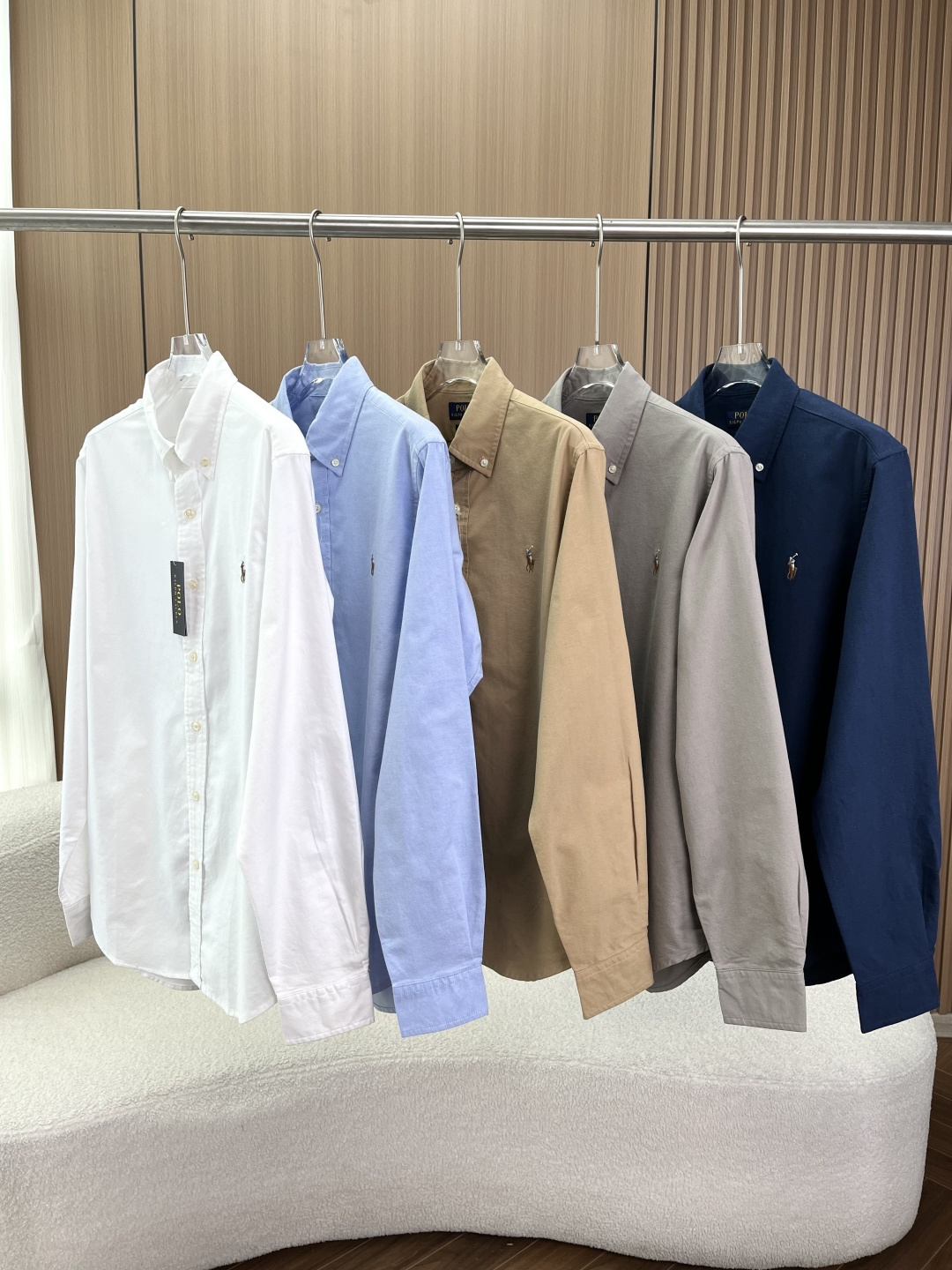 NO:824390,Polo Ralph Lauren (Ralph Lauren polo series) classic Oxford long-sleeved shirt. Brand traceability Polo Ralph Lauren is inspired by polo sports and focuses on the 'American classic casual' style. This Oxford shirt is the brand's iconic product. It was first designed for polo players and later evolved into a versatile style for business and leisure. The style positioning belongs to the brand's 'Core Basic' core basic style, covering all scenarios such as workplace commuting, daily travel, light business, etc., and is a must-have 'universal shirt' for the wardrobe. 1. Collar design  The classic button-down collar (Button-Down Collar) is fixed with a button at each corner of the collar. It was originally used to prevent the collar corners from shaking during polo sports. Now it has become one of the most recognizable designs of the brand. It has a crisp and casual feel, and is not as formal as a pointed collar. The collar seat is moderately high, fits the neck, is not easy to deform after long-term wear, and can still maintain a three-dimensional outline after washing. 2. Placket and buttons  The single-row exposed button design has a delicate luster on the surface, and the buttons of the same color are slightly different in color. The placket is neatly routed, the stitching is fine, and there are no jumps or crooked lines, reflecting the brand's craftsmanship. 3. Iconic embroidered logo. The brand's classic pony rider logo is embroidered on the left chest, with dense embroidery stitches and coordinated proportions. The cuffs are single-button adjustable and can be fine-tuned according to the thickness of the wrist. The sleeve length just covers the wrist, making it suitable for stacking watches.  The core material is combed cotton Oxford Cloth, which is the soul material of this shirt. The warp and weft yarns have different densities, forming a slightly grainy texture. It is soft to the touch but has a stiff feeling, and is more wrinkle-resistant than ordinary pure cotton. The natural breathability of breathable cotton fiber makes it not sweaty when worn in summer, and can be worn as a layered sweater in winter.  A new shirt with an old feel will have a slight starchy feel, which will gradually soften after 3-5 washes, forming a natural 'old' texture, which will fit the skin as it wears. This is also the charm of Oxford shirts. For workplace style, button all the collar buttons, tuck into trousers/khakis, and pair with a belt and loafers, which is simple and capable; for casual style, unbutton 2 buttons on the collar, roll up the cuffs to the forearms, and let the hem hang naturally, and pair it with jeans and sneakers, which is casual and lazy;  Layer style as an inner wear, wear a sweatshirt/knitted cardigan/suit outside, exposing the collar and hem, adding a sense of layering, suitable for autumn and winter.,,loro piana,loafers,hoodie,sweatshirts,jeans,sweaters,shirts,business suit,19860909Polo Ralph Lauren（拉夫劳伦马球系列） 经典牛津纺长袖衬衫 品牌溯源Polo Ralph Lauren 以马球运动为灵感,主打“美式经典休闲”风格,这款牛津纺衬衫是品牌标志性产品,最早为马球运动员设计,后演变为商务休闲百搭款. 款式定位属于品牌的「Core Basic」核心基础款,覆盖职场通勤、日常出行、轻商务等全场景,是衣橱必备的“万能衬衫”. 1. 领型设计 经典纽扣领（Button-Down Collar）领角各有一颗纽扣固定,最初是为了防止马球运动中领角晃动,如今成为品牌辨识度最高的设计之一,兼具挺括感与休闲感,不会像尖领那样过于正式. 领座高度适中,贴合颈部,久穿不易变形,洗后仍能保持立体轮廓. 2. 门襟与纽扣 单排明扣设计,表面有细腻光泽,同配色款纽扣颜色略有差异. 门襟走线工整,针脚细密,无跳线、歪线,体现品牌工艺水准. 3. 标志性刺绣Logo 左胸位置绣有品牌经典小马骑手Logo,刺绣针脚密实、比例协调. 袖口为单扣可调节设计,可根据手腕粗细微调,袖长刚好覆盖手腕,适合叠戴手表. 核心材质精梳棉牛津纺（Oxford Cloth）,这是该款衬衫的灵魂材质 纹理经纬纱线密度不同,形成轻微的颗粒感纹理,触感柔软却自带挺括感,比普通纯棉更抗皱； 透气性棉纤维的天然透气性,夏季穿着不闷汗,冬季可作为内搭叠穿毛衣； 旧化感新衬衫带有轻微浆感,洗水3-5次后会逐渐变软,形成自然的“做旧”质感,越穿越贴合肌肤,这也是牛津纺衬衫的魅力所在. 职场风将领扣全部扣好,塞进西裤/卡其裤,搭配皮带与乐福鞋,简洁干练； 休闲风解开领口2颗纽扣,卷起袖口至小臂,下摆自然垂落,搭配牛仔裤与板鞋,随性慵懒； 叠穿风作为内搭,外面套卫衣/针织开衫/西装,露出领角与下摆,增加层次感,适合秋冬季节.,,loro piana,loafers,hoodie,sweatshirts,jeans,sweaters,shirts,business suit,,Women's clothing