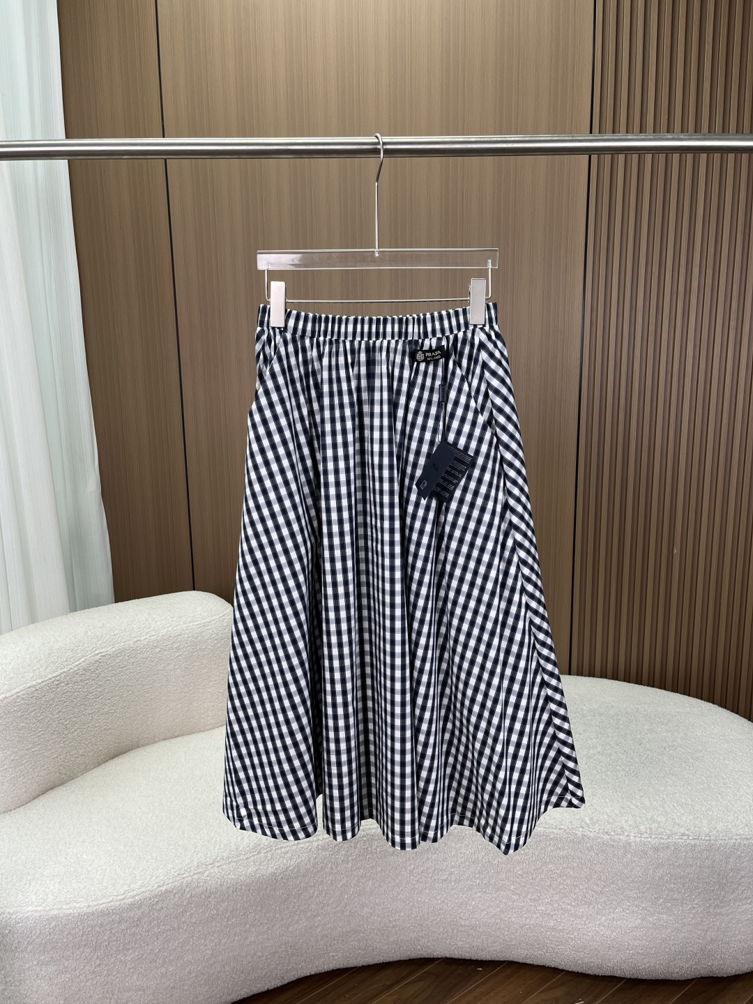 NO:824351,Prada Style Navy Blue Plaid A-Line Skirt】 Combining retro college style with everyday relaxation, this skirt is a versatile item that can never go wrong in the wardrobe. Fabric｜Drapping and breathable, with high-end texture. It is made of stiff and anti-wrinkle high-count cotton blended fabrics.  Style｜A-line silhouette, pear-shaped figure. High-waist elastic waist design, not picky about the waist, comfortable and not tight; A-line large skirt, cleverly modify the width of the hips and thick legs, visually slim and hide the flesh, even fat girls can easily control, walking with a sense of smart atmosphere. Details｜Hide exquisiteness in every place. Original woven label + brand logo, restore texture, full of details  The side invisible pocket design is practical and considerate, making it convenient to go out every day without carrying a bag. The elastic waistband is easy to put on and take off, and is very tolerant to the body shape. The mid-length length just covers the thickest part of the calf, making you look taller and slimmer. Style｜Multiple wears in one skirt, unlock N kinds of combinations  It can be paired with white T-shirts, shirts, and sweaters to easily create a college style, commuting style, or casual style. Whether it is daily outings, commuting to work, or dating, you can easily hold it.,,prada,skirts,shirts,19860909普拉达风藏青格纹A字半裙】 把复古学院风与日常松弛感,穿进夏日的每一天 这条半裙,是衣柜里永不出错的百搭单品 面料｜垂坠透气,自带高级质感 采用挺括抗皱的高支棉混纺面料,上身轻盈不压身,垂坠感绝佳,久坐也不易皱；藏青白格纹,经典耐看,自带复古滤镜,怎么穿都不会过时. 版型｜A字廓形,梨形身材天菜 高腰松紧腰设计,不挑腰围,舒适不勒肉；A字大裙摆,巧妙修饰胯宽、腿粗,视觉上显瘦又藏肉,微胖女生也能轻松驾驭,走路自带灵动氛围感. 细节｜把精致藏在每一处 原版织唛+品牌标识,还原质感,细节拉满 侧边隐形口袋设计,实用又贴心,日常出门不用带包也方便 松紧腰头,穿脱方便,对身材包容性极强 中长款长度,刚好遮住小腿最粗的位置,显高又显瘦 风格｜一裙多穿,解锁N种搭配 可搭配白T、衬衫、针织衫,轻松打造学院风、通勤风、休闲风,不管是日常出街、上班通勤还是约会,都能轻松hold住.,,prada,skirts,shirts,,Women's clothing