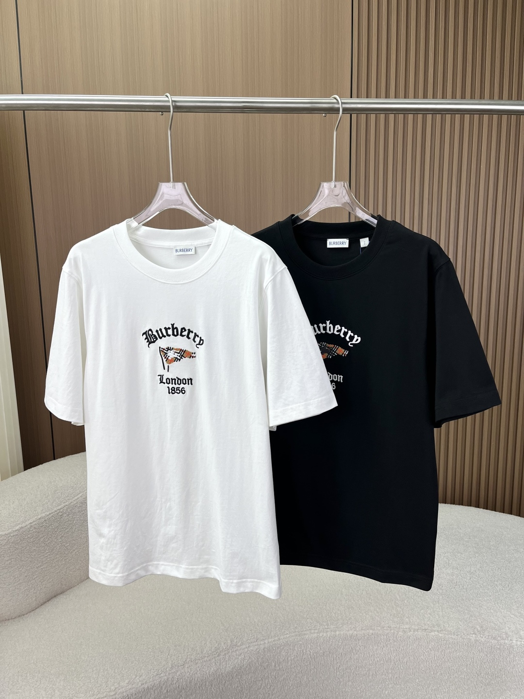 NO:846357,Burberry's classic 1856 embroidered T-shirt. Unisex high-count cotton silhouette short-sleeved shirt. Brings century-old British elegance into daily life. Unobtrusive, but with a high-end aura. This is the essence of old money style. [Brand DNA·Re-engraved classic logo] The brand's iconic Gothic font embroidery is restored on the chest, with 'London'  1856' origin logo, the classic plaid flag adopts 10,000-needle embroidery technology, the stitches are smooth and dense, the edges are clean and neat, and the threads will not fall off after repeated machine washing. The low-key and not exaggerated design, people who understand can get the texture at a glance, bid farewell to the bad logo models on the street, and hide the sense of luxury in the details. [Fabric texture · Soft but not collapsed cabinet-level experience]  Selected high-count and high-density plain cotton fabric (compared to standard cabinet-level craftsmanship), it feels soft and skin-friendly, but the upper body has its own stiffness and will not collapse at all. It is not easy to deform or pill after being worn for a long time, and it can maintain its shape after washing. It is breathable in summer and does not feel stuffy when worn. It does not feel like a foreign body when worn next to the skin. It is so comfortable that you don’t want to take it off. [Ecstasy of details and full of craftsmanship]  Three-needle reinforced neckline. The threaded neckline adopts double threading + three-needle stitching technology. It will not loosen and deform after long-term wear and washing. Say goodbye to the embarrassment of 'wearing it twice and collapsing into a bateau neckline.' Precision-sealed lock-stitched shoulder lines, cuffs, and hems are all neatly hemmed, and the lines are evenly routed without excess threads. The quality is evident in the details. The silhouette is cut in a slightly loose and dropped shoulder version, regardless of body shape or gender. Boys wear it neatly and loosely, while girls wear it in a lazy and casual way. [Outfit scene ·  Covering all styles] Black and white are essential colors for the wardrobe. They are refreshing and versatile when worn alone, and they also have a sense of hierarchy when worn alone. For boys, pair them with linen trousers/straight-leg jeans + white shoes, which is a proper old-money style daily wear. For girls, pair them with overalls/pleated skirts, which are sweet and cool. Pair them with a suit jacket to instantly become a high-end commuter style, burberry, burberry, skirts, jeans, jackets & coats, T-shirt, tees, t-shirt, business suit,19860909Burberry巴宝莉经典1856刺绣T恤 男女同款高支棉廓形短袖 把百年英伦的优雅底蕴,穿进日常里 不张扬,却自带高级气场,这才是老钱风的精髓【品牌基因 · 复刻经典标识】 胸前还原品牌标志性哥特字体刺绣,搭配「London 1856」起源标识,经典格纹旗帜采用万针刺绣工艺,线迹平整密实,边缘干净利落,反复机洗也不会脱线起毛. 低调不浮夸的设计,懂的人一眼就能get到质感,告别烂大街的logo款,把高级感藏在细节里.【面料质感 · 软而不塌的柜级体验】 甄选高支高密平纹棉面料（对标柜级工艺）,摸起来是软糯亲肤的触感,上身却自带挺括度,完全不会软塌贴肉. 久穿不易变形、不起球,洗后也能保持版型,夏天穿透气不闷汗,贴肤穿也毫无异物感,舒服到不想脱下来.【细节控狂喜 · 匠心工艺拉满】 三本针加固领口螺纹领口采用双车线+三本针工艺,久穿久洗也不会松垮变形,告别“穿两次就垮成一字领”的尴尬 精密包边锁缝肩线、袖口、下摆都做了工整包边处理,走线均匀无多余线头,细节处见品质 廓形剪裁微宽松落肩版型,不挑身材不挑性别,男生穿利落松弛,女生穿慵懒随性【穿搭场景 · 承包全风格】 黑白两色都是衣柜刚需色,单穿清爽百搭,叠穿也自带层次感 男生搭配亚麻西裤/直筒牛仔裤+小白鞋,妥妥的老钱风日常穿搭 女生搭工装裤/百褶裙甜酷感拉满,配西装外套秒变高级通勤风,,burberry,burberry,skirts,jeans,jackets & coats,T-shirt,tees，t-shirt,business suit,,Women's clothing