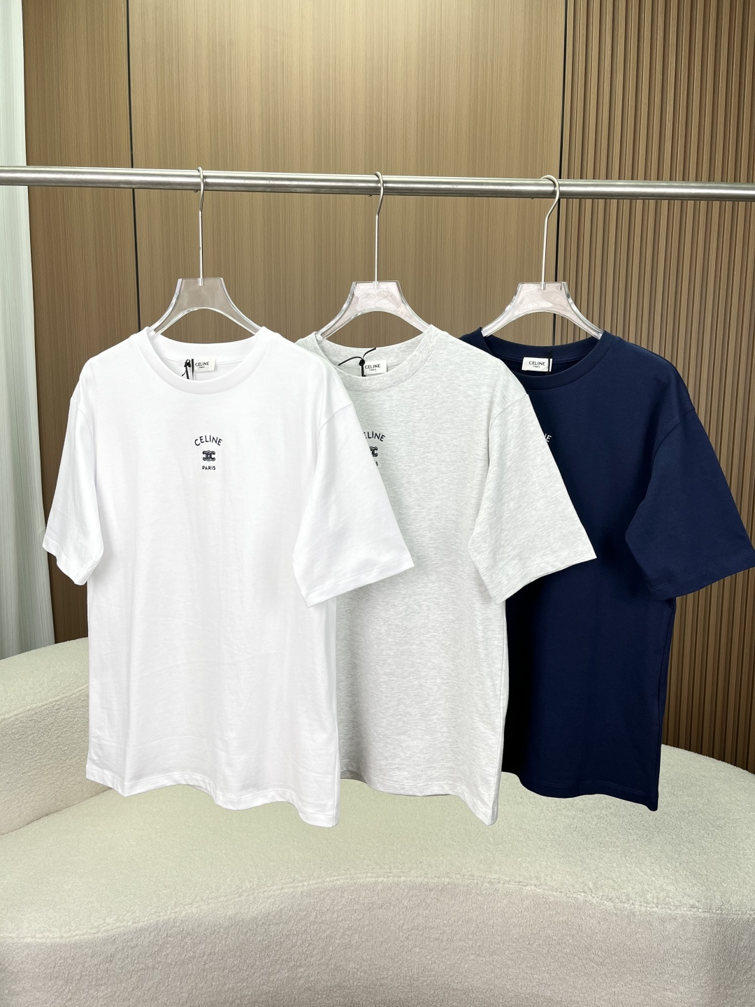 NO:835064,(Original customization for women) Celine Arc de Triomphe embroidered short-sleeved T-shirt comes in three classic colors: light heather, navy blue, and pure white. It focuses on simple, light and luxurious daily casual style, and restores Celine’s iconic Triomphe design elements. Design and appearance features  The core logo is precision embroidered in the same color on the chest, including the curved word 'CELINE', the classic Arc de Triomphe double C (Triomphe) logo and the word 'PARIS'. It is Celine's most recognizable visual symbol, low-key and high-end. The silhouette is a basic round-neck style, a loose off-shoulder version, regardless of body shape, and the same style for men and women. It can be worn alone or layered as an inner layer, suitable for a variety of scenes.  The ribbed round neck design with detailed craftsmanship is not easy to deform after long-term wear; the 'CELINE PARIS' collar label is sewn on the inside of the neckline to restore authentic details; the cuffs and hem are made of double-needle stitching, which is neat and fine, improving the durability of the clothing. The visual texture of the fabric has a moderate drape, and the overall shape is neat and clean without unnecessary decoration, which is in line with Celine's minimalist design aesthetics. Material  The fabric is made of cotton, with combed cotton technology. It is soft against the skin, has good moisture absorption and breathability, and is not sweaty when worn in summer. It feels comfortable to the touch. Washing requirements 1. It needs to be washed with clothes of the same color to avoid cross-color. 2. Clean and iron the reverse side to protect the integrity of the embroidery and fabric. 3. The washing symbol prompts that gentle washing in cold water, do not bleach, do not tumble dry at high temperatures, iron with a low temperature pad, and do not dry clean. Wearing scenarios and matching suggestions  Pair with straight-leg suit pants + loafers for commuting and workplace, which is simple and capable, suitable for light business scenes, and highlight the professional feel. For daily casual wear, pair with straight-leg jeans/sports pants + white shoes to create a relaxed look, suitable for weekend trips and shopping. Wear it layered with a denim jacket, baseball uniform or windbreaker to add a sense of layering, suitable for the transition season between spring and autumn, and enhance the sophistication of your look.  Color matching reference: light heather gray is gentle and age-reducing, navy blue is calm and white, pure white is refreshing and clean, you can choose freely according to your personal style and skin color.,,celine,loafers,jeans,jackets & coats,T-shirt,tees,t-shirt,business suit,19860909（女款原版定制） Celine（思琳）凯旋门刺绣短袖T恤 浅麻灰、藏青色、纯白色三种经典配色,主打简约轻奢的日常休闲风格,还原了Celine标志性的Triomphe（凯旋门）设计元素. 设计与外观特征 核心标识胸口采用同色系精密刺绣,包含弧形「CELINE」字样、经典凯旋门双C（Triomphe）标识与「PARIS」字样,是Celine最具辨识度的视觉符号,低调彰显高级感. 版型剪裁圆领基础款,宽松落肩版型,不挑身材,男女同款,既能单穿也可作为内搭叠穿,适配多种场景. 细节工艺罗纹圆领设计,久穿不易变形；领口内侧缝有「CELINE PARIS」领标,还原正品细节；袖口、下摆采用双针车线,工整细密,提升衣物耐用性. 视觉质感面料垂坠感适中,整体版型利落干净,无多余装饰,符合Celine极简主义的设计美学. 材质 面料成分棉,精梳棉工艺,亲肤柔软、吸湿透气性佳,夏季穿着不闷汗,触感舒适. 洗涤要求 1. 需与同色衣物一起清洗,避免串色. 2. 反面清洁和熨烫,保护刺绣与面料完整性. 3. 洗涤符号提示建议冷水轻柔洗涤、不可漂白、不可高温烘干、低温垫布熨烫、不可干洗. 穿着场景与搭配建议 通勤职场搭配直筒西装裤+乐福鞋,简约干练,适配轻商务场景,凸显专业感. 日常休闲搭配直筒牛仔裤/运动束脚裤+小白鞋,打造松弛感穿搭,适合周末出行、逛街. 叠穿内搭外搭牛仔外套、棒球服或风衣,增加层次感,适配春秋过渡季,提升造型精致度. 配色参考浅麻灰温柔减龄,藏青色沉稳显白,纯白色清爽干净,可根据个人风格与肤色自由选择.,,celine,loafers,jeans,jackets & coats,T-shirt,tees，t-shirt,business suit,,Women's clothing