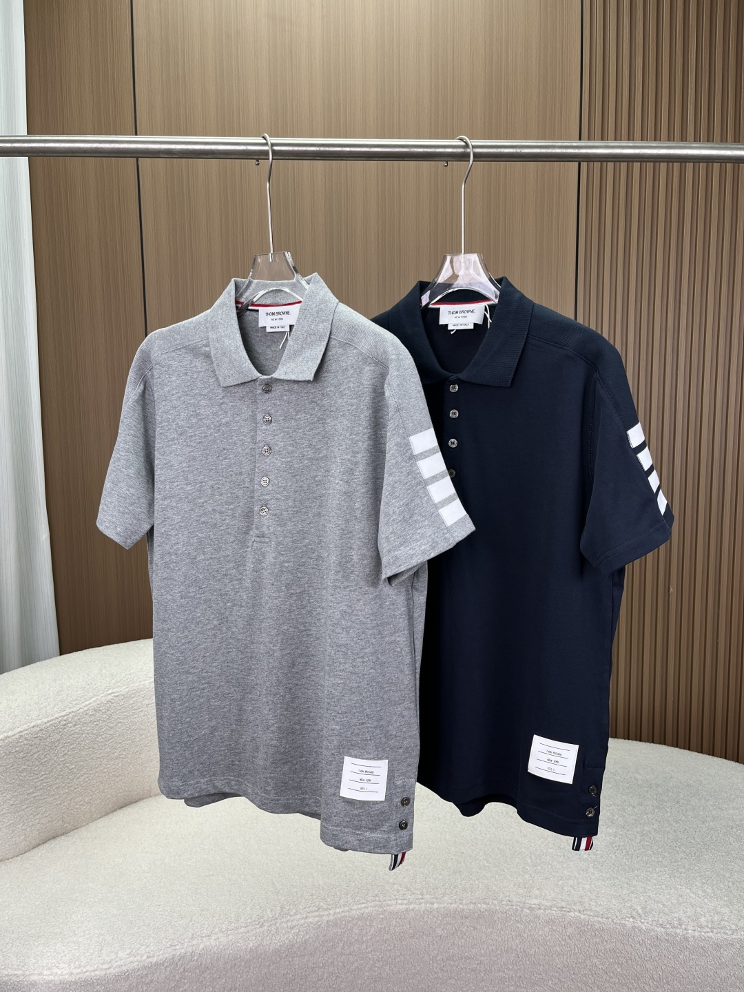 NO:835057,Thom Browne Four Stripes Short Sleeve T-Shirt Polo Shirt. The four horizontal stripes on the iconic four stripes left sleeve are the most recognizable symbol of the brand. They originate from the American college style and convey the brand identity in a low-key manner. The lapel and placket are classic lapel designs with a five-button placket. The inside of the collar is decorated with red, white and blue grosgrain webbing (RWB stripes), which is a classic detail of the brand.  The hem and label have a high-low hem design with short front and long back, and button slits on the side seams; a brand information label is sewn on the hem, and there is also a webbing logo on the back collar, with rigorous craftsmanship. Color matching style: Gray is clean and refreshing, suitable for spring and summer, with a youthful and college style. Navy blue is calm and advanced, a classic brand color, suitable for business and leisure scenes. 2. Fabrics and craftsmanship  The main fabric is made of high-count pique cotton, which is breathable and sweat-absorbent, stiff and stylish, and is comfortable and not stuffy to wear in summer. Craftsmanship details: Made in Italy, with neat stitching, fine seams, and reinforced collars, cuffs and other parts, making it durable and not easily deformed. The four stripes are made of yarn-dyed or intarsia knitting technology, with clear and three-dimensional stripes that will not fall off due to washing. Most of the buttons are made of natural materials, with a warm texture. 3. Scenes and Outfits Applicable Scenarios  Pair with trousers/casual trousers + loafers for business commuting to create an elite and capable image. Pair with Bermuda shorts/jeans + white shoes for daily college style to restore the American preppy style. For layering style in spring and autumn, wear a suit jacket, knitted cardigan or baseball jacket to enhance the sense of layering. For couples, this style is unisex and is the same style for men and women, so it can be worn as a couple outfit.,,loafers,shorts,jeans,jackets & coats,jackets &  coats, T-shirt, tees, t-shirt, business suit,19860909Thom Browne 四道杠短袖T恤Polo衫 标志性四道杠左袖的四条水平条纹是品牌最具辨识度的符号,源自美式学院风,低调传递品牌身份. 翻领与门襟经典翻领设计,搭配五粒纽扣门襟,领口内侧饰有红白蓝三色罗缎织带（RWB条纹）,是品牌的经典细节. 下摆与标签前短后长的高低下摆设计,侧缝带有纽扣开衩；下摆处缝有品牌信息标签,后领也有织带标识,工艺严谨. 配色风格 灰色干净清爽,适合春夏,自带少年感与学院风. 藏青色沉稳高级,是品牌经典色,适配商务与休闲场景. 二、面料与工艺 主面料采用高支珠地棉,透气吸汗、挺括有型,夏季穿着舒适不闷. 工艺细节 意大利制造,车线工整,锁边细腻,领口、袖口等部位做了加固处理,耐穿不易变形. 四道杠采用色织或嵌花针织工艺,条纹清晰立体,不会因洗涤而脱落. 纽扣多为天然材质,质感温润. 三、场景与穿搭 适用场景 商务通勤搭配西裤/休闲西裤+乐福鞋,打造精英干练形象. 学院风日常搭配百慕大短裤/牛仔裤+小白鞋,还原美式预科生风格. 叠穿造型春秋季外搭西装外套、针织开衫或棒球夹克,提升层次感. 情侣穿搭该款为中性设计,男女同款,可作为情侣装搭配.,,loafers,shorts,jeans,jackets & coats,jackets & coats,T-shirt,tees，t-shirt,business suit,,Women's clothing