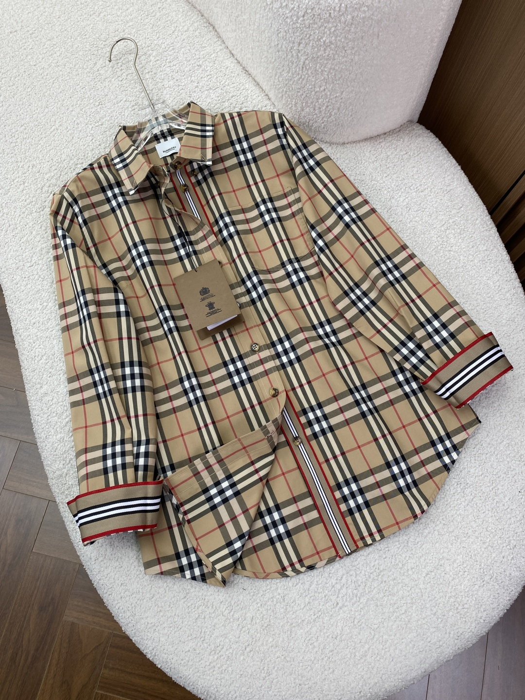 NO:885004,Burberry women's classic plaid long-sleeved shirt!  Burberry, a luxury brand from the United Kingdom, uses the iconic Vintage plaid pattern to create this timeless classic shirt. It is the soul of the brand, combining British style and daily practicality. It can easily adapt to various scenarios such as commuting, leisure, and light business. It is an 'evergreen style' in the wardrobe. The iconic plaid pattern is an instantly recognizable British style. It adopts Burberry's classic Vintage  Checkered pattern, beige base with black, white and red lines, retro and high-end, with its own brand recognition. The iconic red, white and black webbing details at the placket and cuffs, as well as the brand's exclusive amber buttons, low-key highlight the brand identity. The chest patch pocket design takes into account practicality and layering, and is simple but not monotonous. Pure cotton fabric, both comfortable and textured  High-quality pure cotton fabrics are selected, with a delicate and smooth touch. The upper body is breathable and skin-friendly, and is not easy to wrinkle or deform. The crisp version can easily support the shape and say goodbye to the soft feeling. It is very neat whether worn alone or under a suit. The versatile version is suitable for a variety of styles and body types. The classic slightly loose version can be easily controlled regardless of the figure, even if you are fat or thin, hiding the flesh and showing off your temperament.  A variety of ways to wear it, you can wear it refreshingly and neatly alone, wear it with a suit to create a light business style, pair it with jeans to create a casual British style, you can wear it in a variety of styles. This Burberry classic plaid shirt is a single product that combines brand style and daily practicality. Whether it is daily wear or business occasions, you can easily wear it with a high-end texture. It is the best choice to enhance your clothing.,,burberry,burberry,shirts,business suit,19860909Burberry 巴宝莉女款经典格纹长袖衬衫！ 来自英国的奢侈品牌 Burberry,以标志性的 Vintage 格纹,打造这件永不过时的经典衬衫.它是品牌的灵魂之作,兼具英伦格调与日常实穿性,轻松适配通勤、休闲、轻商务等多种场景,是衣橱里的“常青款”. 标志性格纹,一眼识别的英伦格调 采用 Burberry 经典 Vintage 格纹,米色底搭配黑、白、红线条,复古又高级,自带品牌辨识度. 门襟、袖口处的标志性红白黑织带细节,以及品牌专属的琥珀色纽扣,低调彰显品牌身份. 胸前贴袋设计,兼顾实用性与层次感,简约不单调. 纯棉面料,舒适与质感兼备 甄选高品质纯棉面料,触感细腻顺滑,上身透气亲肤,不易起皱变形.挺括的版型能轻松撑起造型,告别软塌感,无论是单穿还是内搭西装都很利落. 百搭版型,适配多种风格与身材 经典微宽松版型,不挑身材,微胖/偏瘦都能轻松驾驭,藏肉又显气质. 多种穿法解锁单穿清爽利落,内搭西装打造轻商务风,搭配牛仔打造休闲英伦风,一件穿出多种风格. 这件 Burberry 经典格纹衬衫,是兼具品牌格调与日常实用性的单品,不管是日常穿搭还是商务场合,都能让你轻松穿出高级质感,是提升衣品的不二之选.,,burberry,burberry,shirts,business suit,,Women's clothing