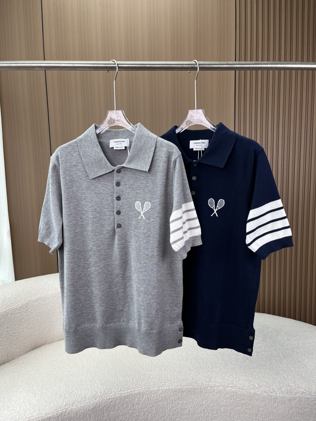 NO:844776,Thom Browne Tennis Racket Embroidered Wool Knitted Polo Shirt TB has a high-end college-style ceiling, welding classicity and texture to the body. The brand's iconic design of classic four-stripes + tennis racket embroidery on the chest, plus a three-color woven logo on the back collar, low-key highlights the brand recognition. It has a high-end college style, and the upper body instantly enhances your temperament.  The wool skin-friendly fabric is made of fine wool knitted fabric, which is soft and skin-friendly, breathable and not sweaty, and has a good drape feeling. It is suitable for single wear in spring and autumn or as an inner layer in autumn and winter, taking into account comfort and texture. The neatly tailored version has a classic Polo collar + placket button design, and the short front and back long hem with side slits make the body more layered, loose and not flattering, and can be easily used in daily commuting and leisure occasions.  Detailed craftsmanship includes shell-like buttons, neat embroidery, and precise threading. Every detail highlights the brand's quality. It is durable and not easily deformed, making it easy to adapt to your multi-season outfits. Choose from two classic colors: navy blue/light gray. It is suitable for jeans, casual pants, suit pants and other bottoms. It is easy to create different styles. It is a versatile item in the wardrobe. This Thom  Browne knitted Polo shirt perfectly combines the brand's iconic elements with high-end texture. Whether worn alone or layered, it can easily create a simple yet high-end college style atmosphere and easily become the highlight of the outfit~,,jeans,business suit,19860909Thom Browne 网球拍刺绣羊毛针织Polo衫 TB自带高级感的学院风天花板,把经典和质感焊在身上 品牌标志性设计经典四道杠条纹+胸口网球拍刺绣,加上后领三色织标,低调彰显品牌辨识度,自带高级学院格调,上身瞬间提升气质. 羊毛亲肤面料采用细腻羊毛针织面料,触感柔软亲肤,透气不闷汗,自带良好垂坠感,春秋单穿、秋冬内搭都很合适,兼顾舒适与质感. 利落剪裁版型经典Polo领+门襟纽扣设计,前短后长下摆搭配侧边开叉,修饰身形更具层次感,宽松不挑身材,日常通勤、休闲场合都能轻松驾驭. 细节工艺拉满贝壳质感纽扣、工整刺绣工艺、精密走线处理,每一处细节都彰显品牌品质,耐穿不易变形,轻松承包你的多季穿搭. 两色百搭选择藏青/浅灰两种经典配色,适配牛仔裤、休闲裤、西装裤等多种下装,轻松打造不同风格造型,是衣柜里的百搭刚需款. 这款Thom Browne针织Polo衫,把品牌标志性元素与高级质感完美融合,无论是单穿还是叠穿,都能轻松穿出简约又高级的学院风氛围,轻松成为穿搭亮点~,,jeans,business suit,,Women's clothing