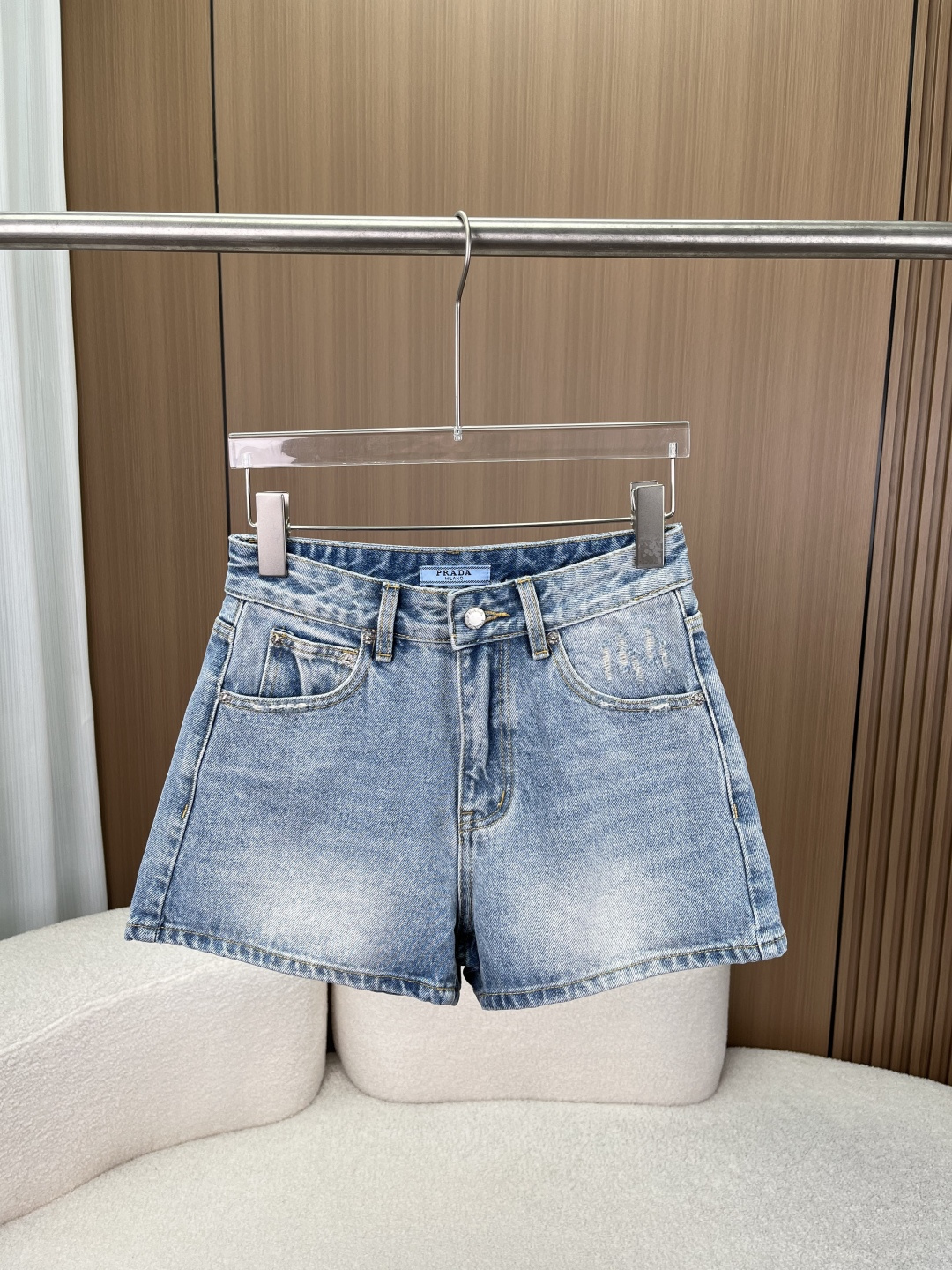 NO:861890,Prada triangle logo denim shorts!  Retro distressed high-waisted hot pants!  Prada's classic triangular metal logo on the back pocket, with contrasting black and silver colors, is instantly recognizable and is the brand's iconic design. The buttons and zippers are custom-made by the brand, and the details highlight the high-end texture, making it easy to create an elegant and sassy street style. Fabrics and craftsmanship  Heavy denim fabrics are selected and treated with special washing and distressing, giving them a natural retro color and a crisp and stylish touch. The fabrics are wear-resistant and wrinkle-resistant, not easily deformed, and can maintain a neat silhouette even after long-term wear. Precision sewing technology ensures neat stitching and smooth edge locking, making it durable and not easy to fall off. Highlights of the pattern and design  The high-waisted straight cut and high-waistline design optimizes body proportions, corrects short body parts such as hip width and thick legs, and has an outstanding slimming effect. The pants are neat and neat, and have a neat feeling when walking. The distressed and frayed details at the pockets add a retro street feel to the simple pants, breaking the dullness and making them more personalized. Practical multi-pocket design. The front and rear multi-pocket design takes into account both beauty and practicality, and can be used to store small items, making daily travel more convenient.  Classic denim color, retro light blue wash color, versatile and easy to adapt to various styles, it is a must-have and versatile item in the wardrobe. Style adaptation Whether it is paired with a short top to create a hot girl style, or paired with a sweater or T-shirt to create a casual daily look, it can be easily controlled and suitable for daily life, vacation, street and other scenes.,, prada, prada, hoodie, sweatshirts, shorts, tees, t-shirt,19860909Prada 普拉达三角标牛仔短裤 ！ 复古做旧高腰热裤！ 后袋处Prada经典三角金属标,黑银撞色自带辨识度,是品牌标志性设计；纽扣、拉链均为品牌定制款,细节处彰显高级质感,轻松打造又A又飒的街头风格. 面料与工艺 甄选重磅牛仔面料,经过特殊水洗做旧处理,呈现自然复古色泽,触感挺括有型；面料耐磨抗皱,不易变形,久穿依旧保持利落版型；精密车缝工艺,走线工整,边缘锁边平整,耐穿不易脱线. 版型与设计亮点 高腰直筒剪裁高腰线设计优化身材比例,修饰胯宽、腿粗等身材短板,藏肉显瘦效果出众；裤型利落,行走间自带利落感. 做旧磨破细节口袋处磨破设计,为简约裤型增添复古街头感,打破沉闷,更具个性. 实用多袋设计前后多口袋设计,兼顾美观与实用性,可放置随身小物,日常出行更便捷. 经典牛仔配色复古浅蓝水洗配色,百搭不挑人,轻松适配多种穿搭风格,是衣橱必备的百搭单品. 风格适配 无论是搭配短款上衣打造辣妹风,还是搭配卫衣、T恤打造休闲日常造型,都能轻松驾驭,适配日常、度假、街头等多种场景.,,prada,prada,hoodie,sweatshirts,shorts,tees，t-shirt,,Women's clothing