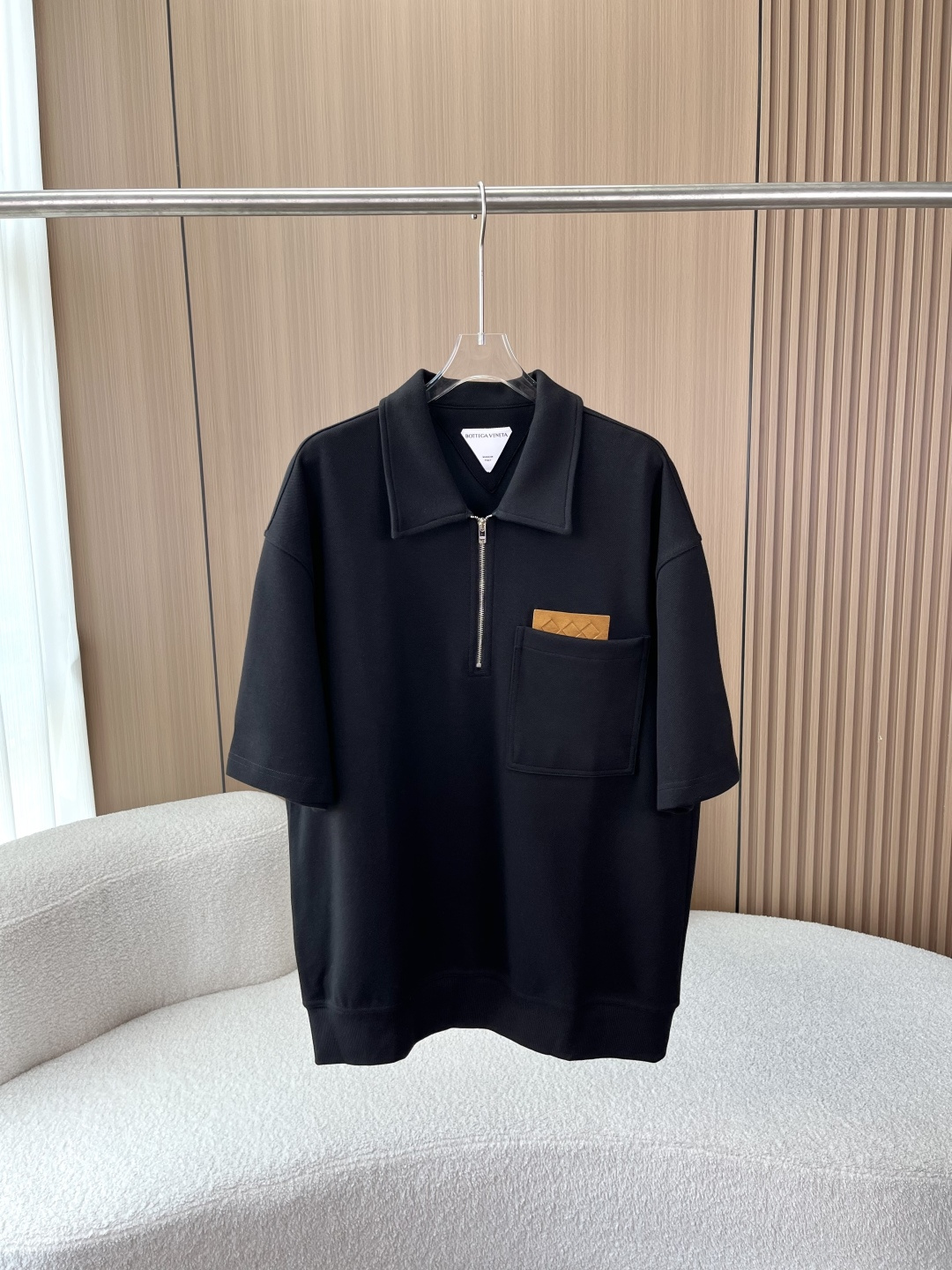 NO:901223,BOTTEGA VENETA (BV) Men's Half-Zip Polo Shirt 1. Style and cut: It adopts a loose shoulder wide cut, which weakens the restraint of the shoulder line. It is highly tolerant to all body shapes (thin, slightly fat, and strong), hides the flesh and makes you look slimmer, and creates an unintentional sense of relaxation. It is BV's iconic 'pressure-free luxury' design.  The proportion of the length of the garment has been optimized, and the hem is ribbed to fit the body shape without collapsing. It will not look bloated when worn alone or layered. 2. Collar shape and placket The large lapel + half-open zipper is the soul design that is different from the traditional button Polo. The zipper can freely adjust the opening and closing of the collar. The zipper can be zipped up neatly and neatly, suitable for business commuting; the zipper can be opened to be lazy and casual, and it can transform into a V-neck in seconds, suitable for daily outings.  The zipper details are customized with silver metal zippers and brand engraved pulls, which are smooth and non-stuck; paired with white double-strand cotton rope anti-oxidation drawstrings. 3. Pockets and brand logo Large left chest patch pocket + brown suede Intrecciato logo Intrecciato (woven) is the soul craft of BV. It is presented in the form of embossing on the first-layer suede label. The contrasting design breaks the boring solid color and is a low-key logo that 'people who know the industry can recognize the brand at a glance'.  The double-strand overlocking process for pocket routing is neat and without jumpers, which is the embodiment of the top quality control of Made in Italy. 5. The fabric is mainly made of heavy pique mesh pure cotton, which is crisp and stylish, not easy to wrinkle, and does not deform after long-term wear; the mesh structure is fully breathable, absorbs sweat and dries quickly, and does not feel stuffy when worn in spring and summer; the texture of heavy cotton becomes softer and has a retro charm. 6. Washing and maintenance  The maximum washing temperature of the water is 30°C. It is recommended to use a weak wash cycle. Do not use bleach, do not tumble dry, and do not iron at high temperatures (steam ironing is prohibited at 110°C). It is recommended that if there are stains on the clothes, it is recommended to consult a professional brand laundry store to maintain the fabric texture and fit. 4. Wear suitability  The style of this Polo shirt is simple and low-key without losing texture. The black version is suitable for business and leisure commuting and daily outings; the gray version is more Japanese-style and relaxed. It can be paired with casual trousers, jeans or straight pants. It is suitable for wearing alone and is an essential item for high-quality men's clothing.,,bottega veneta,bottega veneta,jeans,chamois leather,19860909BOTTEGA VENETA（BV）男士半拉链Polo衫 1. 版型与剪裁 采用宽松落肩阔版剪裁,弱化肩线束缚,对所有身形（瘦、微胖、壮硕）都有极强包容性,藏肉显瘦,打造不刻意的松弛感,是BV标志性的“无压力奢华”设计. 衣长比例经过优化,下摆罗纹收边,贴合身形不垮塌,单穿、叠穿都不会显臃肿. 2. 领型与门襟 大翻领+半开拉链是灵魂设计区别于传统纽扣Polo,拉链可自由调节领口开合度 拉上拉链利落干练,适配商务通勤； 拉开拉链慵懒随性,秒变V领,适配日常出街. 拉链细节定制银色金属拉链,拉头带品牌刻印,顺滑不卡顿；搭配白色双股棉绳防氧化拉绳. 3. 口袋与品牌标识 左胸大贴袋+棕色麂皮Intrecciato标Intrecciato（编织）是BV的灵魂工艺,这里以压纹形式呈现在头层麂皮标上,撞色设计打破纯色沉闷,是“懂行的人一眼识品牌”的低调标识. 口袋走线双股锁边工艺,工整无跳线,是意大利制造的顶级品控体现. 5. 面料 主体为重磅珠地网眼纯棉 挺括有型,不易皱,久穿不变形； 网眼结构透气性拉满,吸汗速干,春夏穿着无闷热感； 重磅棉质感越穿越软,越穿越有复古韵味. 6. 洗护与保养 水温最高洗涤温度30℃,建议使用弱洗程序. 禁忌不可使用漂白剂、不可滚筒烘干、不可高温熨烫（标注110℃禁止蒸汽熨烫）. 建议衣物如有污渍,建议咨询专业的品牌洗护店,维持面料质感与版型. 4. 穿搭适配性 这款Polo衫风格简约低调且不失质感,黑色款适合商务休闲通勤、日常出街；灰色款更偏向日系松弛感.可搭配休闲西裤、牛仔裤或直筒裤,单穿外搭都很合适,是高品质男装的刚需单品.,,bottega veneta,bottega veneta,jeans,chamois leather,,Women's clothing