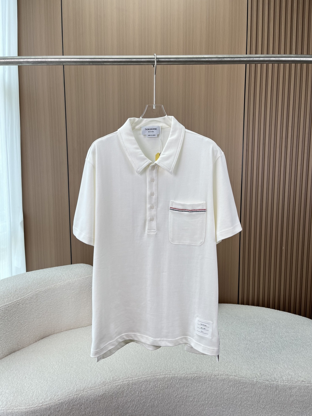 NO:901209,(High quality) THOM BROWNE classic white label color stripe Polo shirt!  TB's high-end expression of minimalism puts the brand's DNA on the body. This THOM BROWNE Polo shirt integrates the brand's iconic red, white and blue elements into every detail. The three-color embroidery on the edge of the pocket woven label is the most recognizable brand logo. Every stitch is neat and delicate, replicating the classic aesthetics. The side slit on the hem and the iconic webbing + double buckle design are not only an ingenious idea for putting on and taking off, but also the brand language when walking.  The THOM BROWNE cloth label on the collar and tag, the accompanying yellow tag, and the clear brand information on the wash label fully retain the authentic traceability details. Fabric and pattern The selected fabric is made of high-count piqué cotton, which has a clear and breathable texture, is both stiff and skin-friendly, and the upper body is not easy to collapse and deform. The tailoring design is a classic slightly loose version of the brand, which is not picky about the figure, and can be worn loosely in daily wear without being deliberate. It can be easily matched with jeans and trousers.  Craftsmanship details, contrast stitching, flat seams, shell-like buttons, and neat and clean lines from collar to cuffs, can withstand the picky details. Wearing Scenarios Whether it is worn with a casual suit when commuting, or paired with shorts on the weekend to create a relaxed look, this THOM BROWNE Polo shirt can be adapted to a variety of scenes. It uses low-key brand symbols to create an effortless sense of luxury.,,shorts,jeans,business suit,19860909（高品质） THOM BROWNE经典白标彩条Polo衫！ TB极简主义的高阶表达,把品牌DNA穿在身上 这件THOM BROWNE Polo衫,将品牌标志性的红白蓝元素融入每一处细节 口袋织标胸前口袋边缘的三色刺绣,是辨识度拉满的品牌标识,每一针都工整细腻,复刻经典美学 下摆侧开叉侧边标志性织带+双扣设计,既是穿脱的巧思,也是行走间的品牌语言 领标与吊牌领部的THOM BROWNE布标、附带的黄色吊牌,以及洗水标上清晰的品牌信息,完整保留正品溯源细节 面料与版型 甄选面料采用高支珠地棉面料,肌理清晰透气,兼具挺括感与亲肤性,上身不易软塌变形 剪裁设计品牌经典微宽松版型,不挑身材,日常穿松弛不刻意,搭配牛仔裤、西裤都能轻松驾驭 工艺细节撞色缝线、平整锁边、贝壳质感纽扣,从领口到袖口的走线都利落干净,经得起细节控的挑剔 穿搭场景 无论是通勤时搭配休闲西装,还是周末搭配短裤打造松弛感造型,这件THOM BROWNE Polo衫都能适配多种场景,用低调的品牌符号,穿出不费力的高级感.,,shorts,jeans,business suit,,Women's clothing