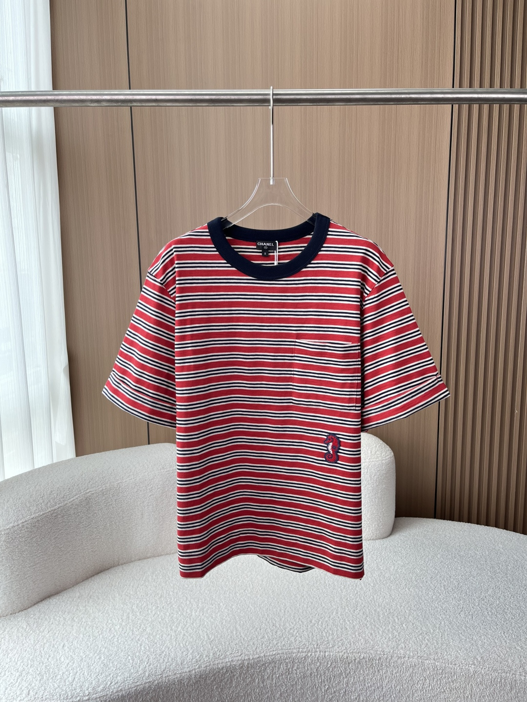 NO:877297,Chanel retro striped seahorse embroidered short-sleeved T-shirt | French nautical style daily top!  The CHANEL nautical style striped T-shirt made of selected pure cotton fabrics perfectly combines French retro and casual atmosphere, and is a must-have item for the wardrobe. 1. Color design｜Classic contrasting stripes Red + navy blue + off-white three-color horizontal stripe combination, with the retro genes of French sea soul shirts, navy ribbed round neck contrasting body, weakening the sense of monotony, yellow leather upper body whitening skin, regardless of skin color. 2.  Iconic details | Handmade seahorse embroidery. Handmade seahorse embroidery logo is embellished next to the side pockets of the body, and the brand's double C logo is embedded in the embroidery.  The loose and slightly off-shoulder short-sleeve cut accommodates various body shapes. The small side slits at the hem are designed to optimize the body lines without being tight or pressing. You can switch between daily tuck-in corners and loose straight wear; the cuffs are neatly hemmed, and the threads are fine and durable. 4. Fabric texture｜100% cotton, skin-friendly and breathable  The whole piece is made of cotton knitted fabric, which is soft, breathable, moisture-wicking, and suitable for both spring and summer wear alone and autumn and winter inner layering. The fabric is soft and waxy and not easy to deform and pill, making it easy to handle during daily commuting and outings.  From classic sea soul stripes to exquisite seahorse embroidery, CHANEL brings light luxury and casual style. It is suitable for wearing alone with jeans, skirts and casual shorts. It is a big-name basic model that is frequently worn all year round.,,chanel,chanel,skirts,shorts,jeans,T-shirt,tees,t-shirt,19860909香奈儿复古条纹海马刺绣短袖T恤｜法式航海风日常上衣！ 甄选精选纯棉面料打造的CHANEL香奈儿航海风条纹T恤,把法式复古与休闲氛围感完美融合,是衣橱百搭刚需单品. 1. 配色设计｜经典撞色条纹 红+藏青+米白三色横条纹组合,自带法式海魂衫复古基因,藏青色螺纹圆领撞色衣身,弱化单调感,黄皮上身衬肤显白,不挑肤色穿搭. 2. 标志性细节｜手工海马刺绣 衣身侧口袋旁点缀手工海马刺绣标,刺绣内嵌品牌双C标识,立体勾线工艺扎实精致,小众不浮夸,低调彰显CHANEL品牌质感,小口袋兼顾装饰与实用. 3. 版型剪裁｜舒适随性版型 宽松微落肩短袖剪裁,包容各种身形,下摆侧边开叉小设计,优化衣身线条,不紧绷不压身,日常塞衣角、宽松直穿两种穿法随心切换；袖口工整锁边,走线细密耐穿. 4. 面料质感｜全棉亲肤透气 整件采用全棉针织面料,柔软透气、吸湿排汗,春夏单穿、秋冬内搭都适配,面料软糯不易变形起球,日常通勤、出游逛街轻松驾驭. 从经典海魂条纹到精致海马刺绣,CHANEL把轻奢休闲风拉满,单穿配牛仔裤、半裙、休闲短裤都适配,一年四季高频实穿的大牌基础款.,,chanel,chanel,skirts,shorts,jeans,T-shirt,tees，t-shirt,,Women's clothing