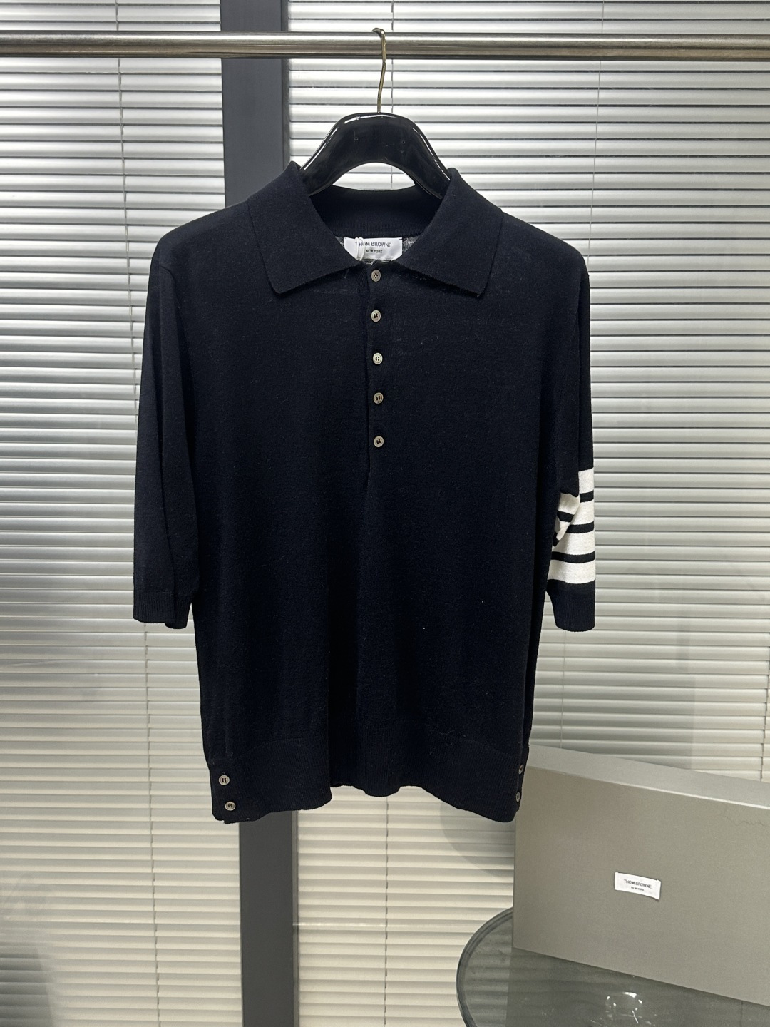 NO:783332,TB2ss fine wool short-sleeved polo is the most representative Polo collar. Its most obvious feature is the iconic white '4-Bar Stripe' on the left arm cuff, which is the brand's visual DNA and symbolizes the spirit of the school sports team. Made of 60-count fine wool, this type of wool has long fiber and few impurities. The clothes made of it not only have good warmth retention, but also have strong pilling resistance and excellent drape.  The Polo collar design has a more retro college style than the traditional V-neck, and is suitable for matching with a shirt or worn alone. The customized shell buttons have a good luster and a high-end texture. The tailoring is slim fit, and there are usually button slits on both sides of the hem, which not only facilitates movement, but also increases the layering of the shape. It is made of high-density weaving, thin and not transparent. It is recommended to dry clean or hand wash in cold water!  !  Size1.2.3.4,thom browne-clothing,thom browne,shirts,T-shirt,19860909TB2ss细羊毛短袖polo 最具代表性的Polo领 其最明显的特征是左臂袖口处有标志性的白色“四条纹”（4-Bar Stripe）,这是品牌的视觉DNA,象征着学校运动队的精神 . 采用60支细羊毛 这种羊毛纤维长、杂质少,制成的衣物不仅保暖性好,而且抗起球能力强,垂坠感极佳 . Polo领设计比传统V领更具复古学院风,适合搭配衬衫或单穿.定制的贝壳扣光泽感好,质感高级 . 剪裁偏合身（Slim Fit）,下摆两侧通常有纽扣开衩设计,既方便活动,也增加了造型层次感 . 采用高密度编织,薄而不透 建议干洗或冷水手洗！！ Size1.2.3.4,汤姆布朗-服装,thom browne,shirts,T-shirt,,Women's clothing