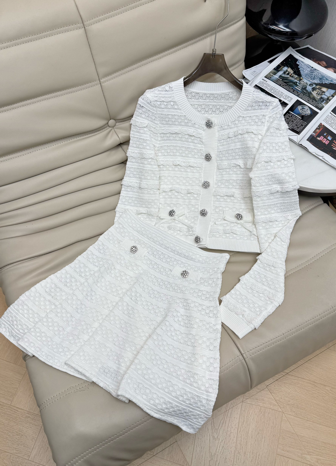 NO:954066,Top and skirt 2026 new white hollow knitted material, delicate texture and super elegant!  The buttons of the round neck top can be opened. The high-waisted skirt directly fills up the proportions and shows the body proportions. The rhinestone buttons are embellished, low-key and sparkling, full of layers, smart and high-end. It can be easily managed on dates, afternoon tea, and light gatherings. Pair it with pearl earrings or a small bag to directly fill up the atmosphere!  SML,,skirts,19860909上衣半裙 2026新品白色镂空针织材质 细腻肌理感超优雅！圆领上衣扣子可打开 高腰裙 比例直接拉满 显身材比例 水钻纽扣点缀,低调闪耀,层次感满满,灵动又高级.约会、下午茶、轻聚会都能轻松驾驭,搭配珍珠耳钉或小包,氛围感直接拉满！ SML,,skirts,,Women's clothing
