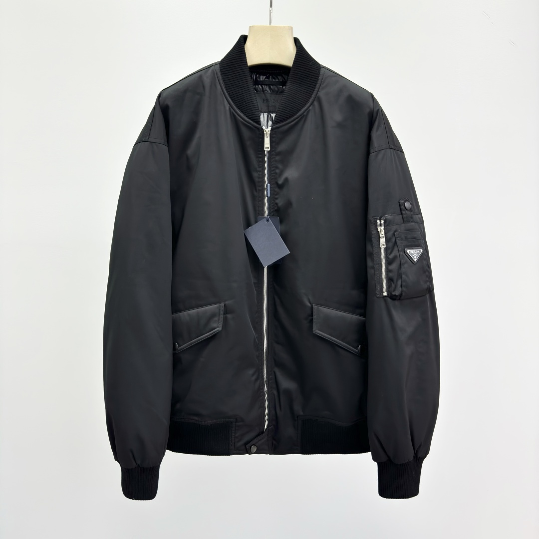 NO:572609,prad@ Regenerated Nylon Bomber Jacket This regenerated nylon bomber jacket features soft volumes and functional details, featuring an enameled triangle logo in metal. Regular fit Ribbed knit collar Straight sleeves Zip closure Button and flap pockets Rib knit cuffs Dropped shoulders Straight hem Lined and quilted Enameled triangle logo in metal  The brand's iconic regenerated nylon (Re-Nylon) fabric is made of recycled yarn, and its raw materials come from recycled and purified plastic materials in the ocean 28325975.0,,prada,jackets & coats,alexander wang19860909prad@ 再生尼龙飞行员夹克 这款再生尼龙飞行员夹克采用柔和体量设计和功能性细节,饰有涂珐琅三角形金属徽标. 常规版型 罗纹针织领 直筒衣袖 拉链开合 纽扣和翻盖口袋 罗纹针织袖口 落肩 平直底边 带衬里和绗缝 涂珐琅三角形金属徽标 品牌标志性的再生尼龙（Re-Nylon）面料采用再生纱线制成,其原料来自海洋中回收净化的塑料材料 28325975.0,,prada,jackets & coats,alexander wang,Men's clothing