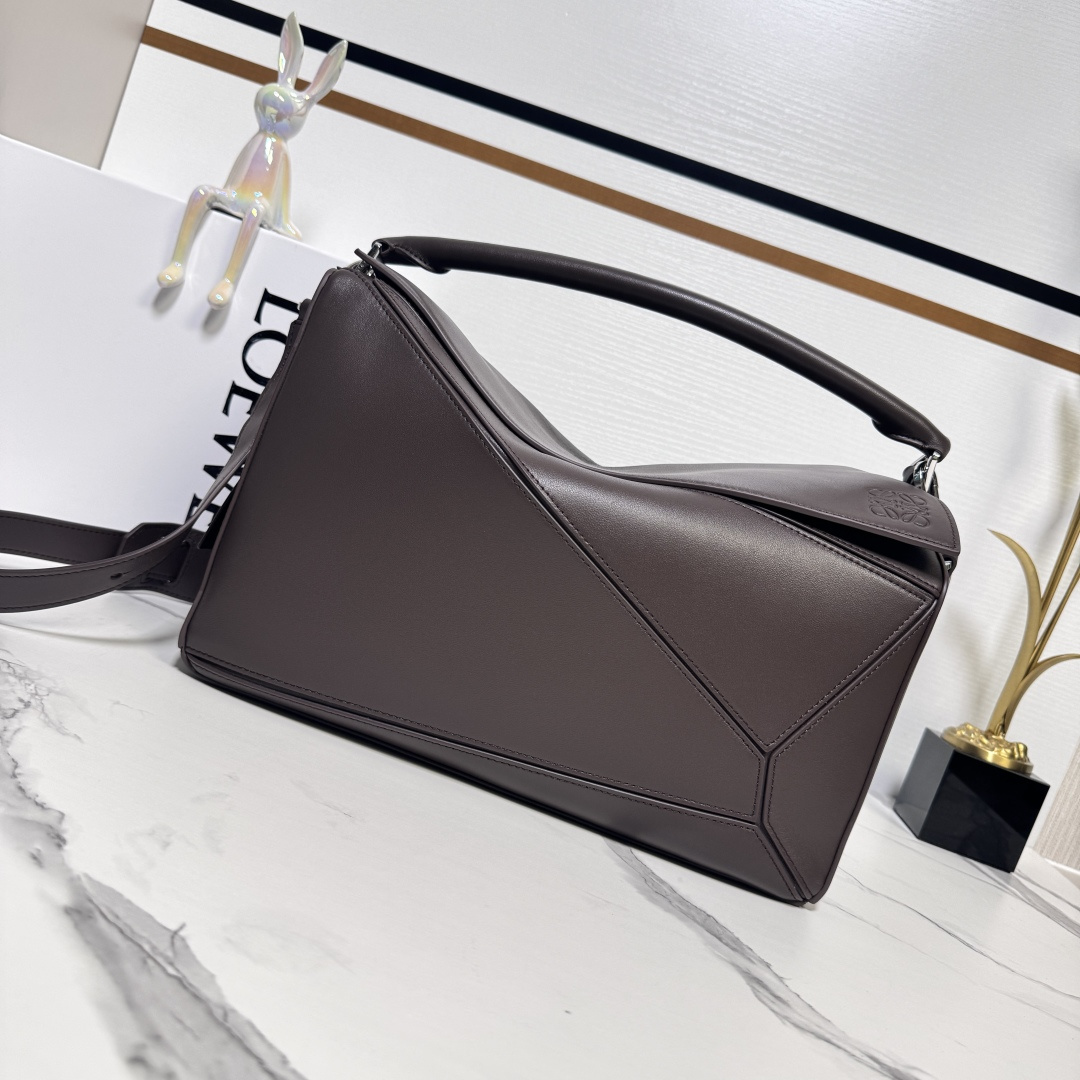 NO:343118,LOw new large size Napa sheep leather Featherlight Puzzle handbag outlines the rectangular shape with unique geometric lines. Soft and light Napa leather injects casual and lazy style into the handbag. It can be shoulder-mounted, cross-body or hand-held Removable adjustable shoulder straps with rotary snap zipper opening and closure, articulated zipper head One external zipper rear pocket, two internal insert pockets* removable LOE**WE gold-pinning or silver-pinning labels with hidden pockets and balloon dice* rectangular metal foot nails Napa sheep leather lining Anagram embossed, engraved internally LOE**WE. Model 652567 size:33*14.7*21.5CM, new sheepskin geometric bag men's puzzle medium size  large size loewe sheepskin19860909LOw新款 大号纳帕羊皮革 Featherlight Puzzle 手袋 以别具一格的几何线条勾勒长方体造型.柔软轻盈的纳帕皮革为手袋注入随性慵懒的风格.可肩背、斜挎或手提 可拆卸可调节肩带,饰有旋转卡扣*拉链开合,铰接式拉链头 一个外部拉链后袋,两个内部插袋*可拆卸 LOE**WE 烫金或烫银标签,饰有隐秘口袋和气球骰子*长方形金属脚钉 纳帕羊皮革衬里 Anagram 压纹、饰牌内部镌刻 LOE**WE. 型号652567 size:33*14.7*21.5CM,羊皮新款几何包男款puzzle中号 大号,loewe,sheepskin,Bag