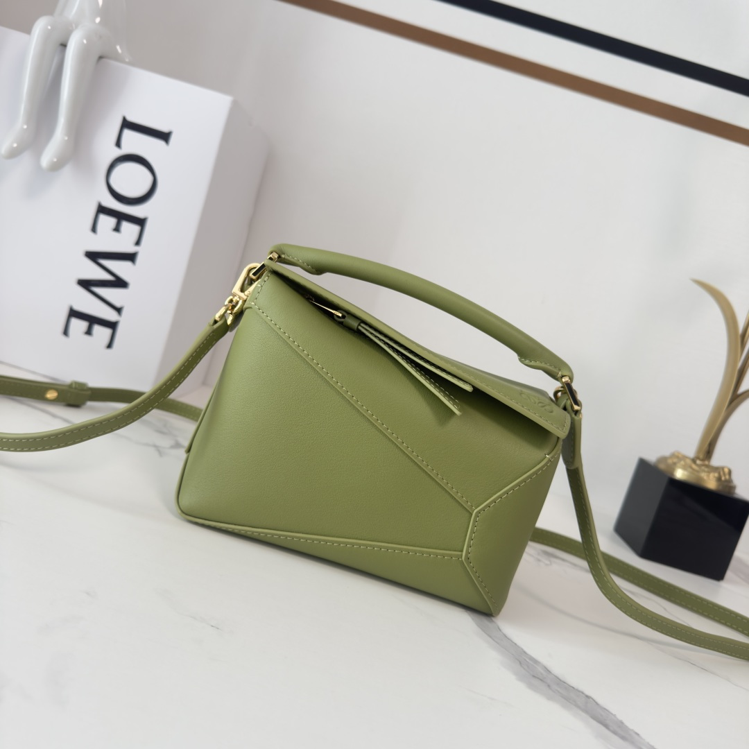 NO:583900,Lw new version mini soft calf leather Puzzle Edge handbag The debut handbag from the house* The cuboid shape and precise cutting techniques create the unique geometric lines of the Puzzle* This mini version takes a classic  Made of calfskin with overlapping edges. Mini Puzzle can hold, for example, a small vertical wallet, most cell phone sizes (up to 6.1 inches) and sunglasses, and can be worn over the shoulder or across the body *Hand or top handle carry*Adjustable, removable shoulder strap*One interior slip pocket and one exterior rear zip pocket  Model 062312 F (with complete packaging), Loewe, loewe, wallets, cowhide19860909Lw新版本 mini柔软牛皮革Puzzle Edge手袋 家推出的首次亮相手提包*长方体形状和精确的切割技术创造了 Puzzle 独特的几何线条*这个迷你 版本采用经典 小牛皮制成,饰有重叠边缘.迷你Puzzle可以容纳例如一只小号垂直钱包,大多数尺寸的手机（最大6.1寸）和太阳镜,肩背或斜挎*手拿或顶部提手携带*肩带可调节,可拆卸*一个内部插袋和一个外部后方拉链口袋*拉链开合带牛皮革拉链头*人字纹棉质帆布衬里Anagram 压纹 size:18*12.5*8CＭ 型号062312 F（配全套包装）,罗意威,loewe,wallets,cowhide,Bag