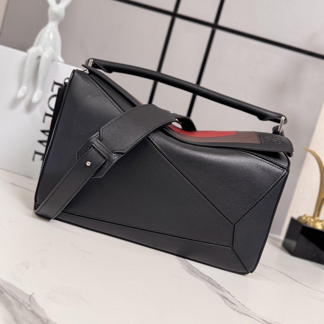 NO:601998,LOw New Dimension Puzzle Bag in Soft Cow Leather Debut handbag from Luo Family * Cuboid shape and precise cutting techniques create the unique geometric lines of the Puzzle * This version is crafted in soft cow leather with overlapping edges for shoulder or cross-body carry * Carry by hand or top handle * Adjustable, removable shoulder strap * External rear zip pocket and two internal slip pockets * Zip closure, cow leather zipper pull * Suede lining * Anagram embossed.  size:052449 model 33*14.7*21.5cm, new size      new puzzle (33CM), loewe, cowhide19860909LOw 新尺寸柔软牛皮革Puzzle 手袋 罗家推出的首次亮相手提包*长方体形状和精确的切割技术创造了 Puzzle 独特的几何线条*此版本采用柔软牛皮革制成,饰有重叠边缘肩背或斜挎*手拿或顶部提手携带*肩带可调节,可拆卸*外部后方拉链袋和两个内部插袋*拉链开合,牛皮革拉链头*绒面革衬里* Anagram压纹. size:052449 型号33*14.7*21.5cm,新尺寸    新款puzzle（33CM）,loewe,c,Bag