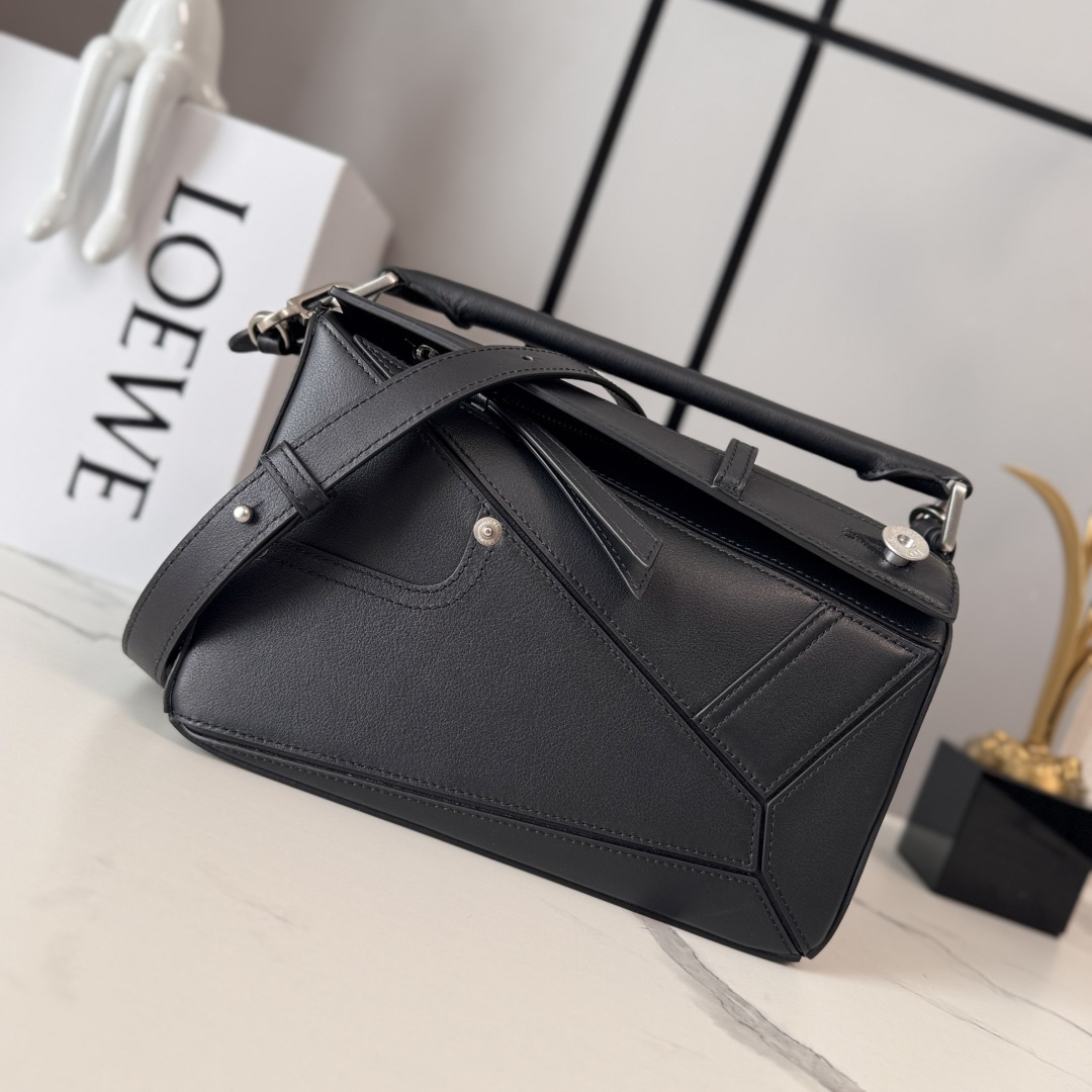 NO:639407,Luojia's new small glossy cow leather Panta Puzzle handbag Puzzle outlines a rectangular shape with unique geometric lines. This small version is made of glossy cowhide and decorated with denim trousers style details. It can be carried on the shoulder, cross-body or handbag * Detachable and adjustable shoulder strap * Zipper closure, cow leather zipper pull * One external zippered back pocket, one internal slip pocket Herringbone cotton canvas lining * Anagram embossing  size: 24*10.5*16.5cm model 052557 (with complete packaging), motorcycle bag (Puzzle Biker), loewe, cowhide19860909罗家新款 小号亮面牛皮革Panta Puzzle 手袋Puzzle 以别具一格的几何线条勾勒长方体造型.此小号版本采用亮面牛皮革制成,饰有单宁布长裤风格细节 .可肩背、斜挎或手提*可拆卸可调节肩带*拉链开合,牛皮革拉链头*一个外部拉链后袋,一个内部插袋人字纹棉质帆布衬里*Anagram 压纹 size: 24*10.5*16.5cm 型号052557（配全套包装）,机车包（Puzzle Biker）,loewe,cowhide,Bag