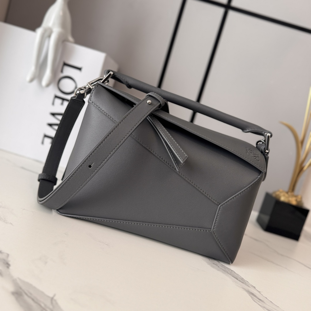 NO:659125,Lw New Version Small Puzzle Edge Handbag in Soft Calf Leather Debut Handbag Launched by Home *Rectangular shape and precise cutting techniques create the Puzzle  Distinctive geometric lines* This small version is made of soft calf leather with overlapping edges. The small Puzzle can hold, for example, a large wallet, mobile phones of all sizes and sunglasses, and can be worn over the shoulder or crossbody* Carry by hand or top handle* Adjustable and removable shoulder strap* One interior slip pocket and one exterior rear zip pocket*Zip closure with cow leather zipper pull*Herringbone cotton canvas lining Anagram embossed size: 24*10.5*16CM  Model 062324 (with complete package), new Puzzle Edge (small size), wallets, cowhide19860909Lw新版本 小号柔软牛皮革Puzzle Edge手袋 家推出的首次亮相手提包*长方体形状和精确的切割技术创造了 Puzzle 独特的几何线条*此小号版本采用柔软牛皮革制成,饰有重叠边缘.小号Puzzle可以容纳例如一只大号钱包,所有尺寸的手机和太阳镜,肩背或斜挎*手拿或顶部提手携带*肩带可调节,可拆卸*一个内部插袋和一个外部后方拉链口袋*拉链开合带牛皮革拉链头*人字纹棉质帆布衬里Anagram 压纹 size:24*10.5*16CM 型号062324（配全套包装）,新款Puzzle Edge（小号）,wallets,cowhide,Bag