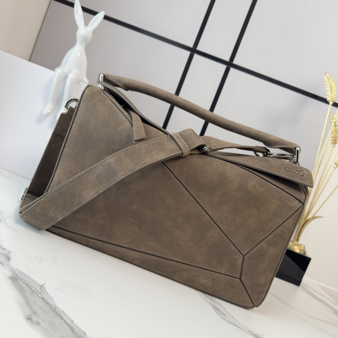 NO:701109,LOw New size large Puzzle bag in grained nubuck. Distinctive geometric lines outline a rectangular shape. This large version is made of grained nubuck leather * Shoulder, cross-body or hand carry * Detachable and adjustable shoulder strap * Zipper closure, cowhide zipper puller * One external zippered back pocket, two internal slip pockets * Rectangular metal feet Nappa sheepskin lining Anagram embossing, plaque engraved inside  LO*E*WE word size:052446 model 33*14..7*21.5cm, men's puzzle medium size, large size, cowhide, sheepskin19860909LOw 新尺寸大号粒面牛巴革Puzzle 手袋 以别具一格的几何线条勾勒长方体造型.此大号版本采用粒面牛巴革制成*肩背、斜挎或手提*拆卸可调节肩带*拉链开合,牛皮革拉链头*一个外部拉链后袋,两个内部插袋*长方形金属脚钉 纳帕羊皮革衬里 Anagram 压纹、饰牌内部镌刻 LO*E*WE 字样 size:052446 型号33*14..7*21.5cm,男款puzzle中号 大号,cowhide,sheepskin,Bag