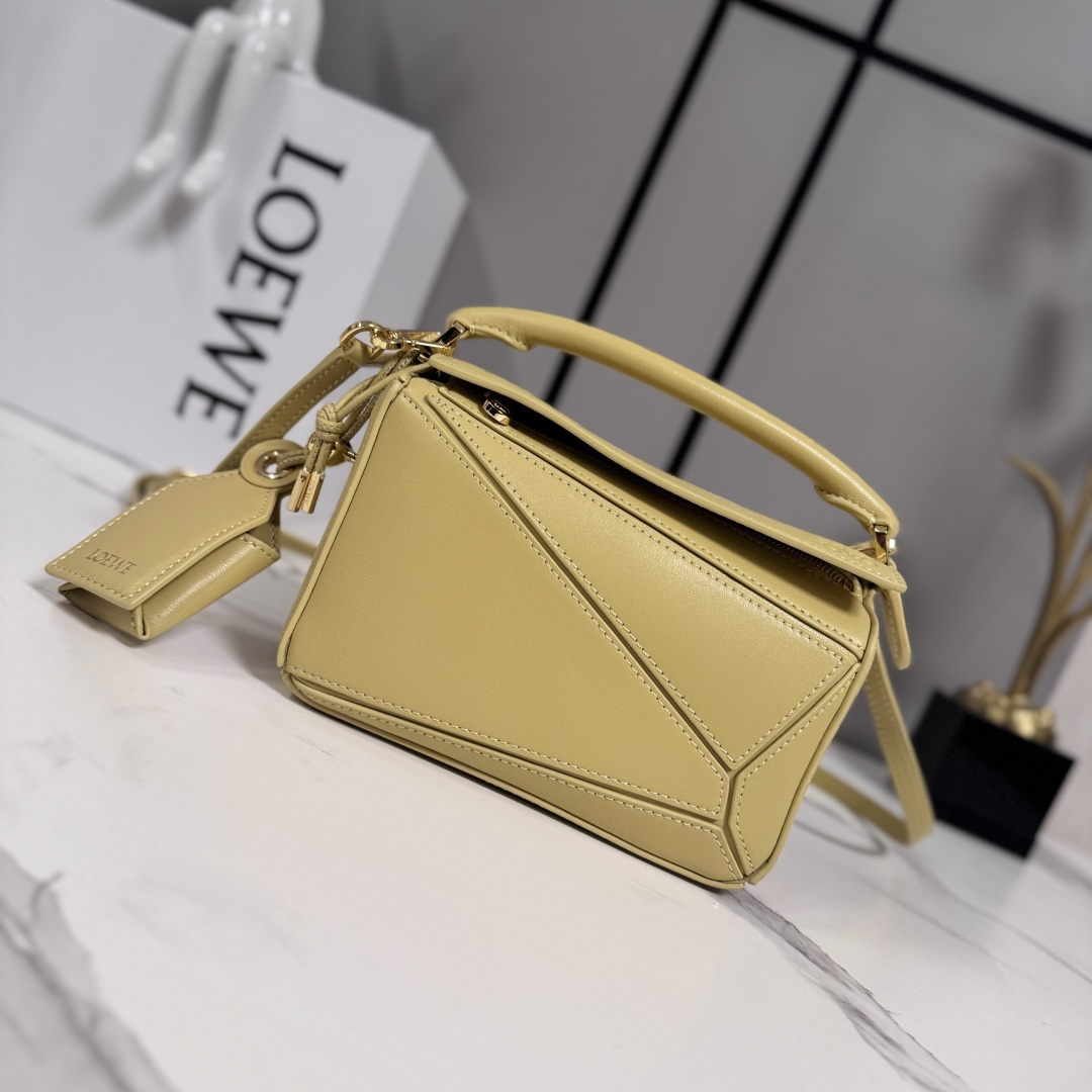 NO:718091,LOw's new mini Nappa sheep leather Featherlight Puzzle handbag outlines a rectangular shape with unique geometric lines. The soft and lightweight Nappa leather injects a casual and lazy style into the handbag. It can be carried on the shoulder, cross-body or handheld. Detachable and adjustable shoulder strap, decorated with rotating buckle*zipper closure, hinged zipper puller. One external zipper back pocket, one internal slip pocket*removable LOE**WE  Hot stamping or silvering label, decorated with secret pockets and balloon dice* Rectangular metal feet Nappa sheep leather lining Anagram embossing, plaque engraved inside LOE**WE. Model 062511 size: 17.5*7.5*12.5CM (with full package), sheepskin-nubuck leather New geometric bag, loewe, sheepskin19860909LOw新款 迷你纳帕羊皮革 Featherlight Puzzle 手袋 以别具一格的几何线条勾勒长方体造型.柔软轻盈的纳帕皮革为手袋注入随性慵懒的风格.可肩背、斜挎或手提 可拆卸可调节肩带,饰有旋转卡扣*拉链开合,铰接式拉链头 一个外部拉链后袋,一个内部插袋*可拆卸 LOE**WE 烫金或烫银标签,饰有隐秘口袋和气球骰子*长方形金属脚钉 纳帕羊皮革衬里 Anagram 压纹、饰牌内部镌刻 LOE**WE. 型号062511 size:17.5*7.5*12.5CM（配全套包装）,羊皮—牛巴革 新款几何包,loewe,sheepskin,Bag