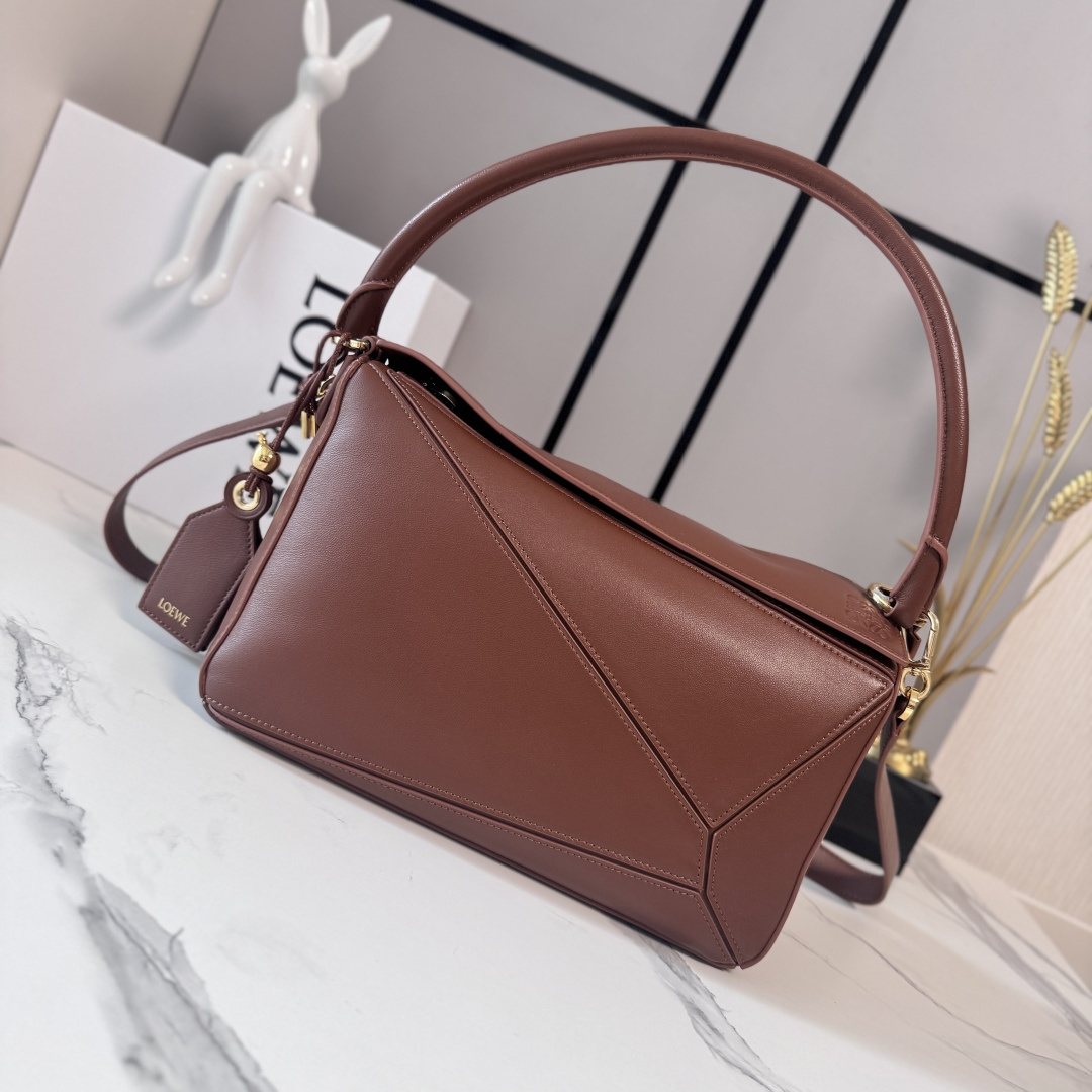 NO:812343,LOw's new medium-sized Nappa sheepskin leather Featherlight Puzzle handbag outlines a rectangular shape with unique geometric lines. The soft and lightweight Nappa leather injects a casual and lazy style. This version is equipped with a shoulder strap, which injects new vitality into the design. It can be carried on the shoulder or cross-body* Detachable and adjustable shoulder strap, decorated with rotating buckle* Zipper closure, hinged zipper puller One external zippered back pocket, one internal slip pocket* Detachable  LOE**WE hot stamping or silver label, decorated with secret pockets and balloon dice* rectangular metal feet Nappa sheep leather lining Anagram embossed, plaque engraved inside LOE**WE wording. Model 062608 size: 29*12*19.5cm (with full package), sheepskin-nubuck leather New geometric bag, loewe, sheepskin19860909LOw新款 中号纳帕羊皮革 Featherlight Puzzle 手袋 以别具一格的几何线条勾勒长方体造型.柔软轻盈的纳帕皮革为手袋注入随性慵懒的风格.此版本配备肩带,为设计注入崭新活力.可肩背、斜挎*可拆卸可调节肩带,饰有旋转卡扣*拉链开合,铰接式拉链头 一个外部拉链后袋,一个内部插袋*可拆卸 LOE**WE 烫金或烫银标签,饰有隐秘口袋和气球骰子*长方形金属脚钉 纳帕羊皮革衬里 Anagram 压纹、饰牌内部镌刻 LOE**WE字样. 型号062608 size:29*12*19.5cm（配全套包装）,羊皮—牛巴革 新款几何包,loewe,sheepskin,Bag