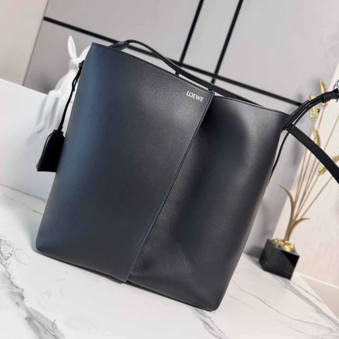 NO:851774,Lw Large Smooth Cow Leather Bilbao Bucket Bag Bilbao Trapezoidal Bucket Bag presents a simple geometric design. It is made of leather splicing, with pleats in the center, and has a soft and close-fitting shape. It is an ideal choice for daily carry. This large version is made of smooth cow leather. The adjustable shoulder strap is detachable for shoulder or cross-body wear Double  L-embossed leather bell-shaped charm with built-in practical bottle opener. Extra external D-ring for matching personalized charms. Hook fastener to secure belongings, suede lining *LOE*WE hot silver Size14×34×27cm Model 062674, new Pebble Hobo handbag, loewe,cowhide19860909Lw大号光滑牛皮革 Bilbao 水桶手袋Bilbao梯形水桶手袋 呈现简约几何设计.采用皮革拼接打造 , 中央饰有褶皱,造型柔软贴身,是日常随身携带的理想选择.此大号版本采用光滑牛皮革制成.肩背或斜挎调节肩带拆卸 Double L压纹皮革钟形挂饰,内藏实用开瓶器.额外的外部D形环用于搭配个性化挂饰.钩扣可固定随身物品,绒面革衬里*LOE*WE烫银 Size14×34×27cm 型号062674,新款Pebble Hobo手袋,loewe,cowhide,Bag