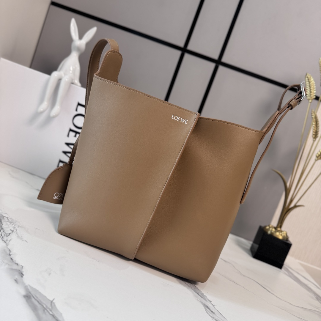 NO:851749,LOw Medium Smooth Bilbao Trapezoidal Bucket Bag with a minimalist geometric design. Crafted from leather panels with central pleats, the soft shape makes it ideal for everyday carry. This medium version is crafted from smooth cowhide. * Shoulder or crossbody * Adjustable shoulder strap * Removable Double L embossed leather bell charm with built-in practical bottle opener * Additional external D-ring for personalized charms * Hook clasp to secure belongings  Suede lining*LOE*WE hot silver. size:13*25*24CM model 652604, new Pebble Hobo handbag, loewe,cowhide19860909LOw中号光滑Bilbao梯形水桶包 呈现简约几何设计.采用皮革拼接打造,中央饰有褶皱,造型柔软贴身,是日常随身携带的理想选择.此中号版本采用光滑牛皮革制成.*肩背或斜挎*调节肩带*拆卸Double L压纹皮革钟形挂饰,内藏实用开瓶器*额外的外部D形环,可用于搭配个性化挂饰*钩扣固定随身物品 绒面革衬里*LOE*WE烫银. size:13*25*24CM 型号652604,新款Pebble Hobo手袋,loewe,cowhide,Bag