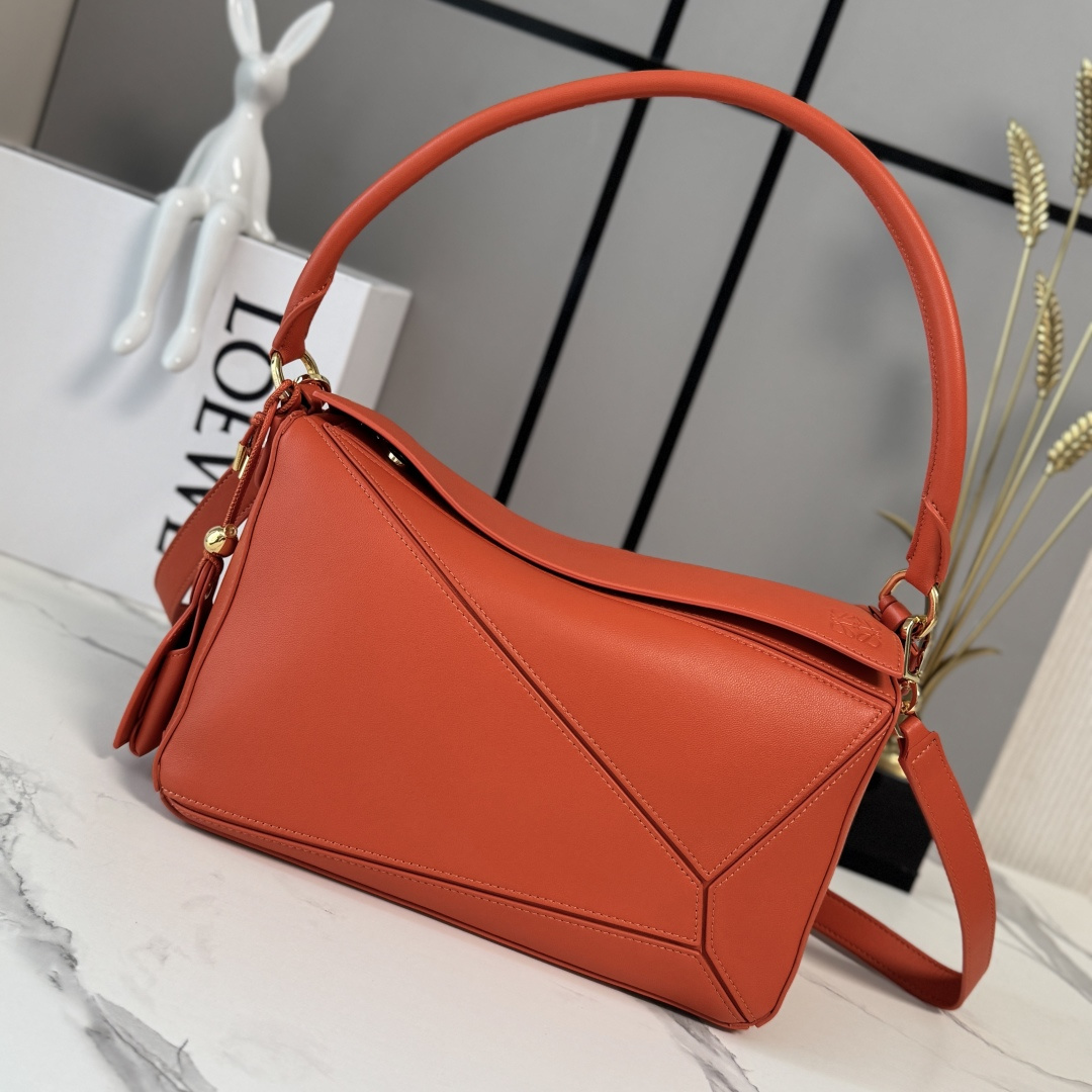NO:851892,LOw's new medium-sized Nappa sheepskin leather Featherlight Puzzle handbag outlines a rectangular shape with unique geometric lines. The soft and lightweight Nappa leather injects a casual and lazy style. This version is equipped with a shoulder strap, which injects new vitality into the design. It can be carried on the shoulder or cross-body* Detachable and adjustable shoulder strap, decorated with rotating buckle* Zipper closure, hinged zipper puller One external zippered back pocket, one internal slip pocket* Detachable  LOE**WE hot stamping or silver label, decorated with secret pockets and balloon dice* rectangular metal feet Nappa sheep leather lining Anagram embossed, plaque engraved inside LOE**WE wording. Model 062608 size: 29*12*19.5cm (with full package), sheepskin-nubuck leather New geometric bag, loewe, sheepskin19860909LOw新款 中号纳帕羊皮革 Featherlight Puzzle 手袋 以别具一格的几何线条勾勒长方体造型.柔软轻盈的纳帕皮革为手袋注入随性慵懒的风格.此版本配备肩带,为设计注入崭新活力.可肩背、斜挎*可拆卸可调节肩带,饰有旋转卡扣*拉链开合,铰接式拉链头 一个外部拉链后袋,一个内部插袋*可拆卸 LOE**WE 烫金或烫银标签,饰有隐秘口袋和气球骰子*长方形金属脚钉 纳帕羊皮革衬里 Anagram 压纹、饰牌内部镌刻 LOE**WE字样. 型号062608 size:29*12*19.5cm（配全套包装）,羊皮—牛巴革 新款几何包,loewe,sheepskin,Bag