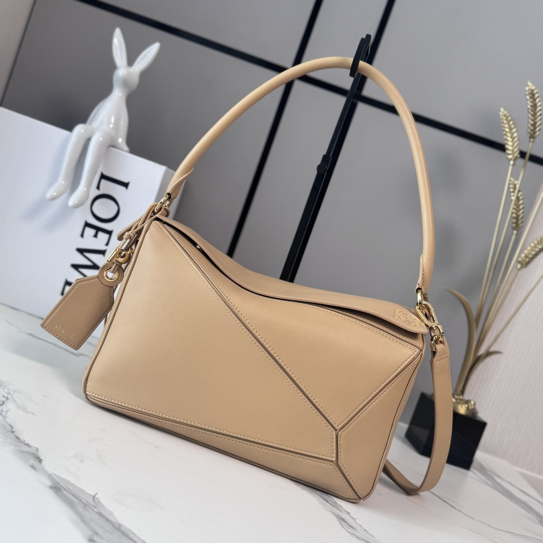 NO:852007,LOw's new medium-sized Nappa sheepskin leather Featherlight Puzzle handbag outlines a rectangular shape with unique geometric lines. The soft and lightweight Nappa leather injects a casual and lazy style. This version is equipped with a shoulder strap, which injects new vitality into the design. It can be carried on the shoulder or cross-body* Detachable and adjustable shoulder strap, decorated with rotating buckle* Zipper closure, hinged zipper puller One external zippered back pocket, one internal slip pocket* Detachable  LOE**WE hot stamping or silver label, decorated with secret pockets and balloon dice* rectangular metal feet Nappa sheep leather lining Anagram embossed, plaque engraved inside LOE**WE wording. Model 062608 size: 29*12*19.5cm (with full package), sheepskin-nubuck leather New geometric bag, loewe, sheepskin19860909LOw新款 中号纳帕羊皮革 Featherlight Puzzle 手袋 以别具一格的几何线条勾勒长方体造型.柔软轻盈的纳帕皮革为手袋注入随性慵懒的风格.此版本配备肩带,为设计注入崭新活力.可肩背、斜挎*可拆卸可调节肩带,饰有旋转卡扣*拉链开合,铰接式拉链头 一个外部拉链后袋,一个内部插袋*可拆卸 LOE**WE 烫金或烫银标签,饰有隐秘口袋和气球骰子*长方形金属脚钉 纳帕羊皮革衬里 Anagram 压纹、饰牌内部镌刻 LOE**WE字样. 型号062608 size:29*12*19.5cm（配全套包装）,羊皮—牛巴革 新款几何包,loewe,sheepskin,Bag