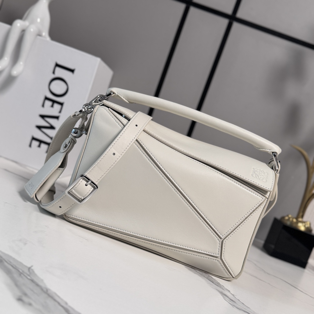 NO:879719,LOw's new small Nappa sheep leather Featherlight Puzzle handbag outlines a rectangular shape with unique geometric lines. The soft and lightweight Nappa leather injects a casual and lazy style into the handbag. It can be carried on the shoulder, cross-body or handheld. Detachable and adjustable shoulder strap, decorated with rotating buckle*zipper closure, hinged zipper puller. One external zippered back pocket, one internal slip pocket*removable LOE**WE  Hot stamping or silvering label, decorated with secret pockets and balloon dice* Rectangular metal feet Nappa sheep leather lining Anagram embossing, plaque engraved inside LOE**WE. size: 062502 Model 24*10.5*16.5cm (with full package), sheepskin-nubuck leather New geometric bag, loewe, sheepskin19860909LOw新款 小号纳帕羊皮革 Featherlight Puzzle 手袋 以别具一格的几何线条勾勒长方体造型.柔软轻盈的纳帕皮革为手袋注入随性慵懒的风格.可肩背、斜挎或手提 可拆卸可调节肩带,饰有旋转卡扣*拉链开合,铰接式拉链头 一个外部拉链后袋,一个内部插袋*可拆卸 LOE**WE 烫金或烫银标签,饰有隐秘口袋和气球骰子*长方形金属脚钉 纳帕羊皮革衬里 Anagram 压纹、饰牌内部镌刻 LOE**WE. size:062502 型号24*10.5*16.5cm（配全套包装）,羊皮—牛巴革 新款几何包,loewe,sheepskin,Bag