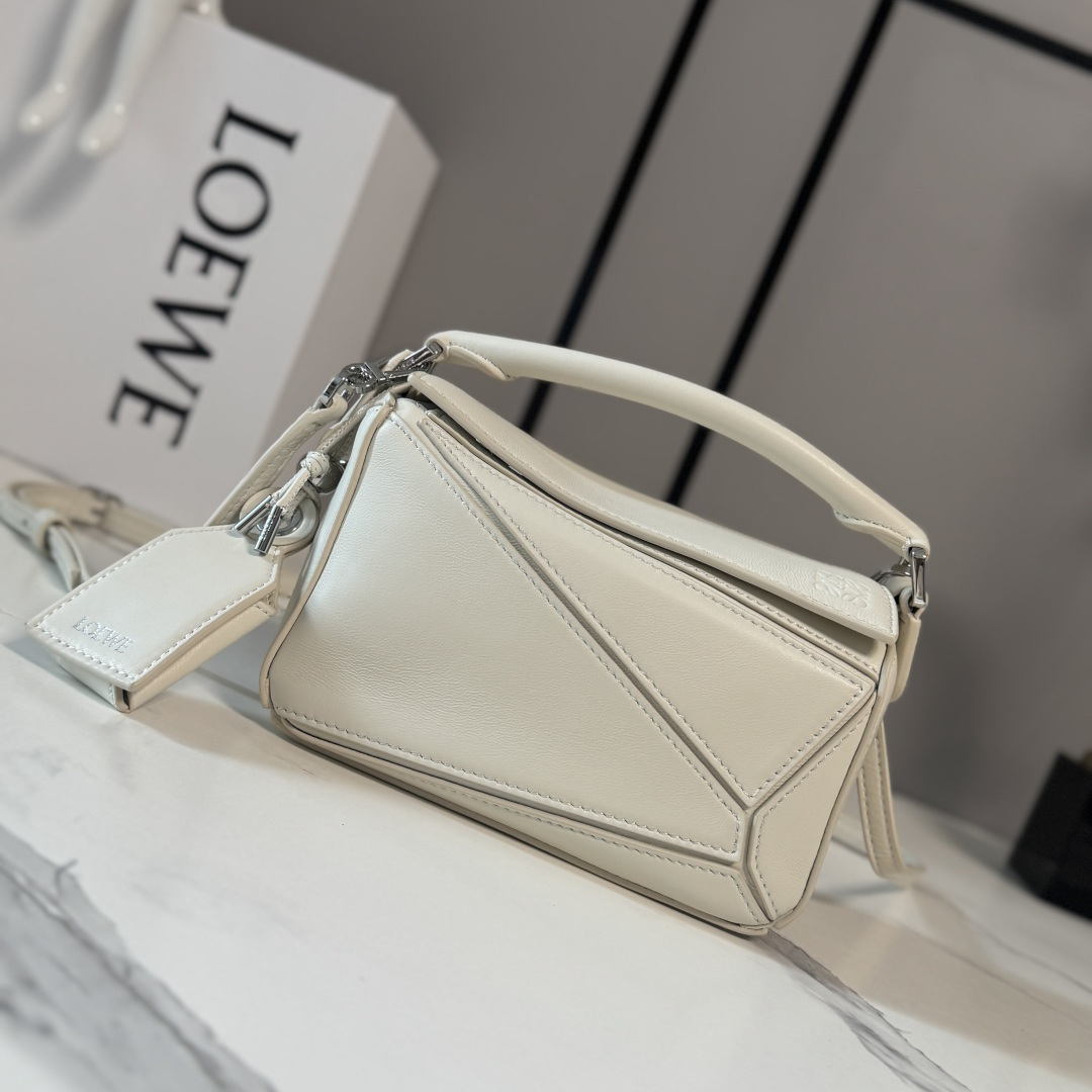 NO:879790,LOw's new mini Nappa sheep leather Featherlight Puzzle handbag outlines a rectangular shape with unique geometric lines. The soft and lightweight Nappa leather injects a casual and lazy style into the handbag. It can be carried on the shoulder, cross-body or handheld. Detachable and adjustable shoulder strap, decorated with rotating buckle*zipper closure, hinged zipper puller. One external zipper back pocket, one internal slip pocket*removable LOE**WE  Hot stamping or silvering label, decorated with secret pockets and balloon dice* Rectangular metal feet Nappa sheep leather lining Anagram embossing, plaque engraved inside LOE**WE. Model 062511 size: 17.5*7.5*12.5CM (with full package), sheepskin-nubuck leather New geometric bag, loewe, sheepskin19860909LOw新款 迷你纳帕羊皮革 Featherlight Puzzle 手袋 以别具一格的几何线条勾勒长方体造型.柔软轻盈的纳帕皮革为手袋注入随性慵懒的风格.可肩背、斜挎或手提 可拆卸可调节肩带,饰有旋转卡扣*拉链开合,铰接式拉链头 一个外部拉链后袋,一个内部插袋*可拆卸 LOE**WE 烫金或烫银标签,饰有隐秘口袋和气球骰子*长方形金属脚钉 纳帕羊皮革衬里 Anagram 压纹、饰牌内部镌刻 LOE**WE. 型号062511 size:17.5*7.5*12.5CM（配全套包装）,羊皮—牛巴革 新款几何包,loewe,sheepskin,Bag