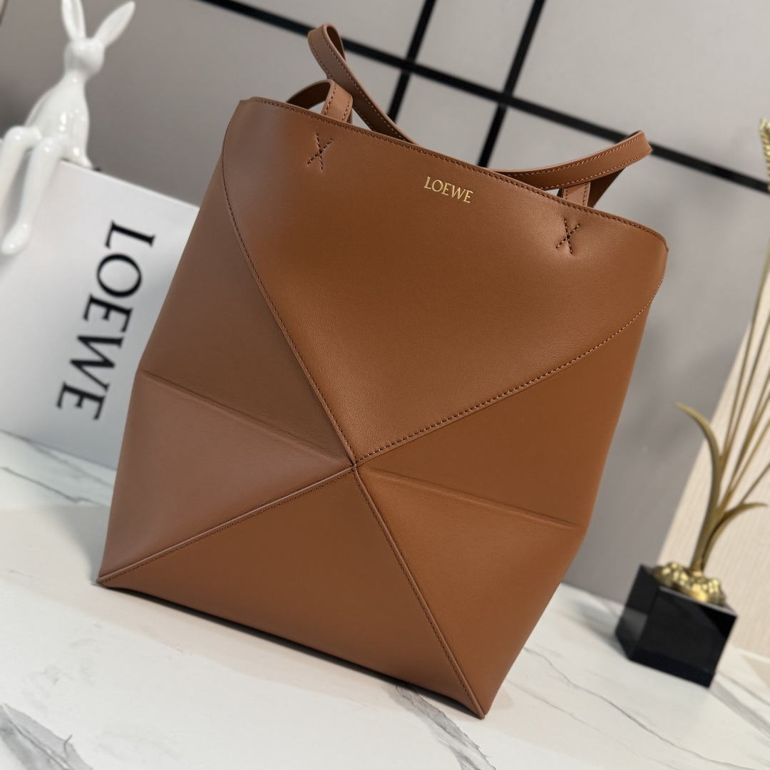 NO:894121,Lw's new small size. Glossy cowhide leather Puzzle Fold Tote takes the signature geometric lines of the iconic bag and redesigns them with graphics and architectural panels. The bag folds completely flat, decorated with understated Lw branding, and can be worn on the shoulder or in the hand. Suede lining Lw hot stamping.19860909Lw新款小号 亮面牛皮革 Puzzle Fold Tote采用标志性包袋的标志性几何线条,并通过图形和建筑面板重新设计它们 使包完全可以折叠平整,饰有低调的 Lw品牌标志,肩背或手提 绒面革衬里Lw烫金. size:25.5*14.5*31.5CＭ 型号052316,折叠包Puzzle Fold Tote,cowhide,Bag