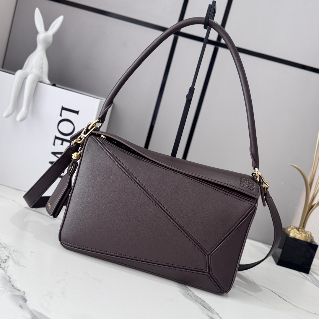 NO:894200,LOw's new medium-sized Nappa sheepskin leather Featherlight Puzzle handbag outlines a rectangular shape with unique geometric lines. The soft and lightweight Nappa leather injects a casual and lazy style. This version is equipped with a shoulder strap, which injects new vitality into the design. It can be carried on the shoulder or cross-body* Detachable and adjustable shoulder strap, decorated with rotating buckle* Zipper closure, hinged zipper puller One external zippered back pocket, one internal slip pocket* Detachable  LOE**WE hot stamping or silver label, decorated with secret pockets and balloon dice* rectangular metal feet Nappa sheep leather lining Anagram embossed, plaque engraved inside LOE**WE wording. Model 062608 size: 29*12*19.5cm (with full package), sheepskin-nubuck leather New geometric bag, loewe, sheepskin19860909LOw新款 中号纳帕羊皮革 Featherlight Puzzle 手袋 以别具一格的几何线条勾勒长方体造型.柔软轻盈的纳帕皮革为手袋注入随性慵懒的风格.此版本配备肩带,为设计注入崭新活力.可肩背、斜挎*可拆卸可调节肩带,饰有旋转卡扣*拉链开合,铰接式拉链头 一个外部拉链后袋,一个内部插袋*可拆卸 LOE**WE 烫金或烫银标签,饰有隐秘口袋和气球骰子*长方形金属脚钉 纳帕羊皮革衬里 Anagram 压纹、饰牌内部镌刻 LOE**WE字样. 型号062608 size:29*12*19.5cm（配全套包装）,羊皮—牛巴革 新款几何包,loewe,sheepskin,Bag