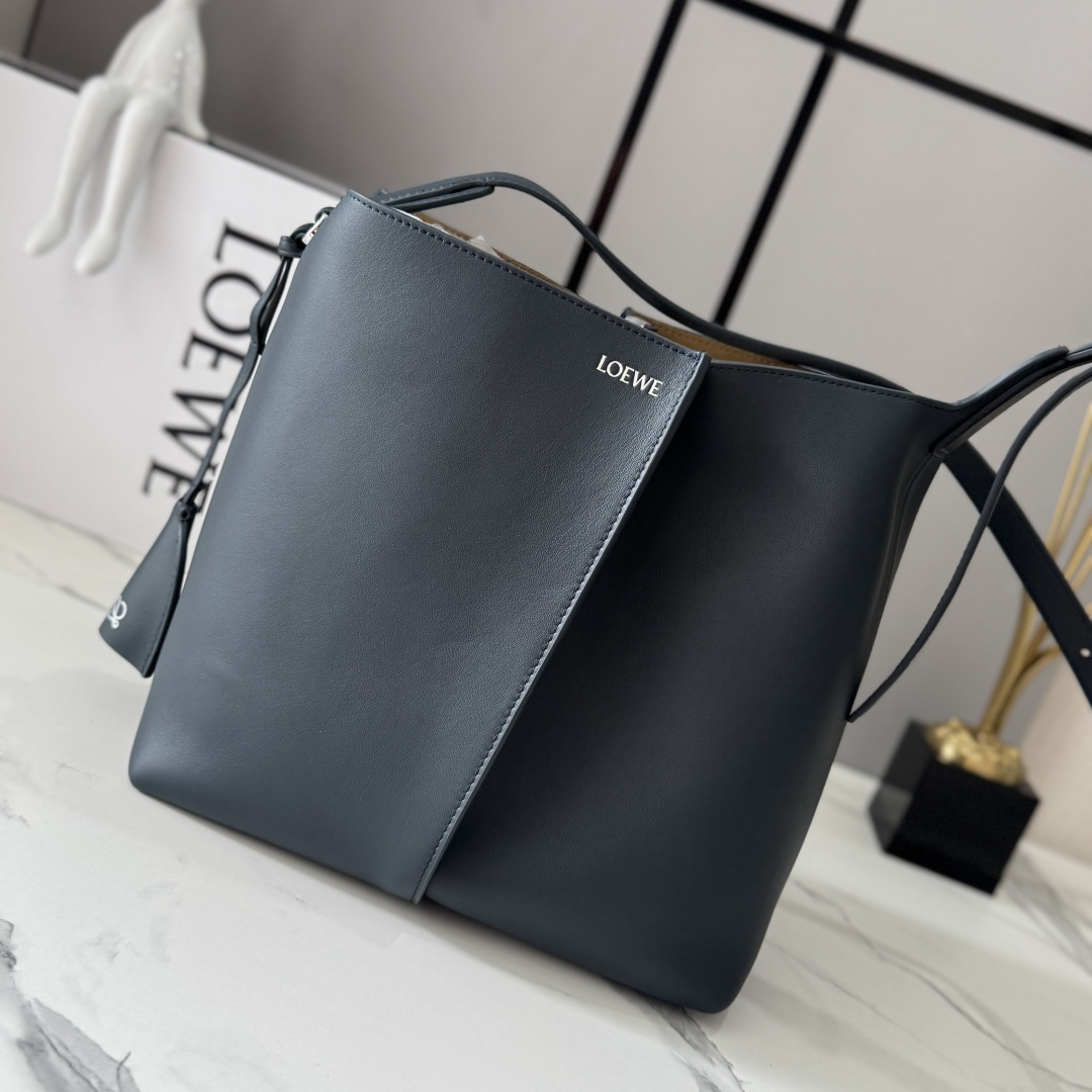 NO:919612,LOw Medium Smooth Bilbao Trapezoidal Bucket Bag with a minimalist geometric design. Crafted from leather panels with central pleats, the soft shape makes it ideal for everyday carry. This medium version is crafted from smooth cowhide. * Shoulder or crossbody * Adjustable shoulder strap * Removable Double L embossed leather bell charm with built-in practical bottle opener * Additional external D-ring for personalized charms * Hook clasp to secure belongings  Suede lining*LOE*WE hot silver. size:13*25*24CM model 652604, new Pebble Hobo handbag, loewe,cowhide19860909LOw中号光滑Bilbao梯形水桶包 呈现简约几何设计.采用皮革拼接打造,中央饰有褶皱,造型柔软贴身,是日常随身携带的理想选择.此中号版本采用光滑牛皮革制成.*肩背或斜挎*调节肩带*拆卸Double L压纹皮革钟形挂饰,内藏实用开瓶器*额外的外部D形环,可用于搭配个性化挂饰*钩扣固定随身物品 绒面革衬里*LOE*WE烫银. size:13*25*24CM 型号652604,新款Pebble Hobo手袋,loewe,cowhide,Bag