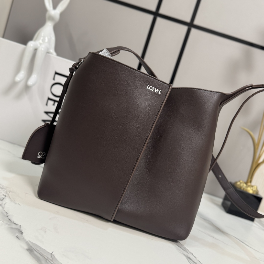 NO:919672,LOw Medium Smooth Bilbao Trapezoidal Bucket Bag with a minimalist geometric design. Crafted from leather panels with central pleats, the soft shape makes it ideal for everyday carry. This medium version is crafted from smooth cowhide. * Shoulder or crossbody * Adjustable shoulder strap * Removable Double L embossed leather bell charm with built-in practical bottle opener * Additional external D-ring for personalized charms * Hook clasp to secure belongings  Suede lining*LOE*WE hot silver. size:13*25*24CM model 652604, new Pebble Hobo handbag, loewe,cowhide19860909LOw中号光滑Bilbao梯形水桶包 呈现简约几何设计.采用皮革拼接打造,中央饰有褶皱,造型柔软贴身,是日常随身携带的理想选择.此中号版本采用光滑牛皮革制成.*肩背或斜挎*调节肩带*拆卸Double L压纹皮革钟形挂饰,内藏实用开瓶器*额外的外部D形环,可用于搭配个性化挂饰*钩扣固定随身物品 绒面革衬里*LOE*WE烫银. size:13*25*24CM 型号652604,新款Pebble Hobo手袋,loewe,cowhide,Bag