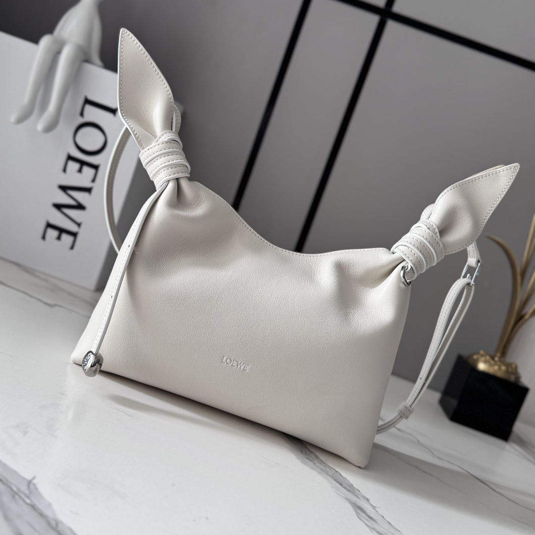 NO:939537,LOw mini scarf bag in smooth calfskin Made from two pieces of fabric, elegantly tied with leather knots and embellished with the new twisted pebble signature. The silhouette is simple and chic, full of feminine charm, reminiscent of a knotted scarf. This mini version is made of smooth calfskin. Adjustable leather shoulder strap * handle, shoulder or crossbody * magnetic closure * suede lining * engraved Anagram pebble LOE**WE hot stamping or silver. Model BA604  Size24.5*6*14.5CM (with full set of packaging), new style     Scarf bag, loewe, cowhide19860909LOw迷你光滑牛皮革Scarf手袋 由两片布料构成,透过皮革绳结优雅系合,并饰有全新扭曲效果pebble标志.廓形简洁别致且充满柔美魅力,让人不禁联想系结围巾.此迷你版本采用光滑牛皮革制成.可调节皮革肩带*提手,肩背或斜挎*磁扣开合*绒面革衬里*镌刻Anagram pebble LOE**WE烫金或烫银. 型号BA604 Size24.5*6*14.5CM（配全套包装）,新款    Scarf包,loewe,c,Bag