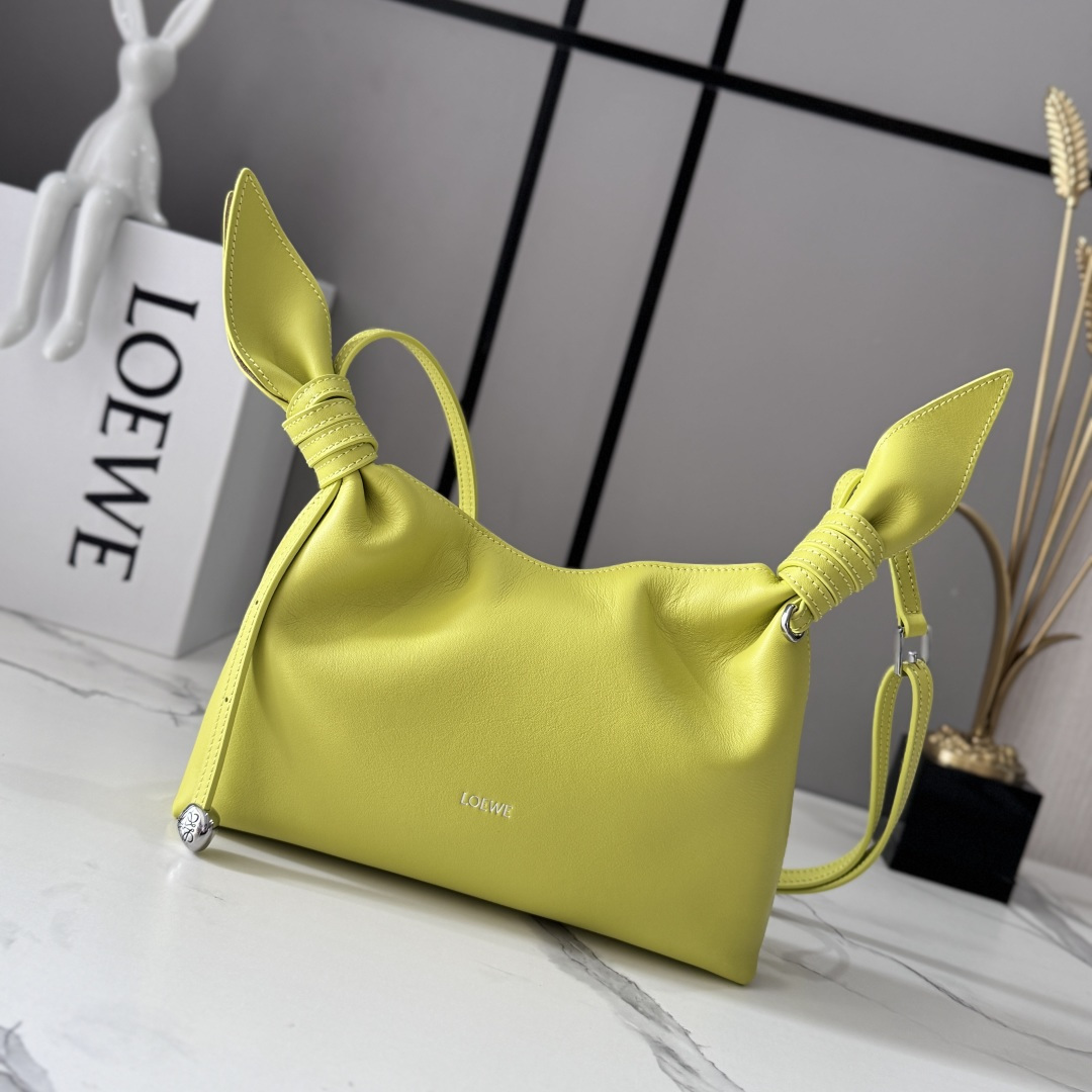 NO:939539,LOw mini scarf bag in smooth calfskin Made from two pieces of fabric, elegantly tied with leather knots and embellished with the new twisted pebble signature. The silhouette is simple and chic, full of feminine charm, reminiscent of a knotted scarf. This mini version is made of smooth calfskin. Adjustable leather shoulder strap * handle, shoulder or crossbody * magnetic closure * suede lining * engraved Anagram pebble LOE**WE hot stamping or silver. Model BA604  Size24.5*6*14.5CM (with full set of packaging), new style     Scarf bag, loewe, cowhide19860909LOw迷你光滑牛皮革Scarf手袋 由两片布料构成,透过皮革绳结优雅系合,并饰有全新扭曲效果pebble标志.廓形简洁别致且充满柔美魅力,让人不禁联想系结围巾.此迷你版本采用光滑牛皮革制成.可调节皮革肩带*提手,肩背或斜挎*磁扣开合*绒面革衬里*镌刻Anagram pebble LOE**WE烫金或烫银. 型号BA604 Size24.5*6*14.5CM（配全套包装）,新款    Scarf包,loewe,c,Bag
