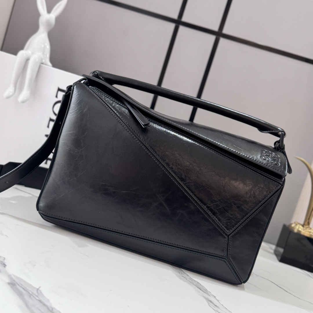 NO:939557,LOw new size large paper grain cow leather Puzzle handbag outlines a rectangular shape with unique geometric lines. This large version is made of wrinkled textured leather. Embellished with matte black accessories * Shoulder, cross-body or hand carry * Detachable adjustable shoulder strap * Zipper closure, cow leather zipper puller * One external zippered back pocket, two internal slip pockets * Metal feet * Suede lining Anagram embossing. size: 052446  Model 33*14·7*21.5cm, men’s puzzle medium size, large new size     New puzzle (33CM), cowhide19860909LOw 新尺寸大号纸纹牛皮革Puzzle 手袋 以别具一格的几何线条勾勒长方体造型.此大号版本采用褶皱纹理皮革制成.点缀哑光黑色配件*肩背、斜挎或手提*拆卸可调节肩带*拉链开合,牛皮革拉链头*一个外部拉链后袋,两个内部插袋*金属脚钉*绒面革衬Anagram压纹. size:052446 型号33*14·7*21.5cm,男款puzzle中号 大号新尺寸    新款puzzle（33CM）,c,Bag