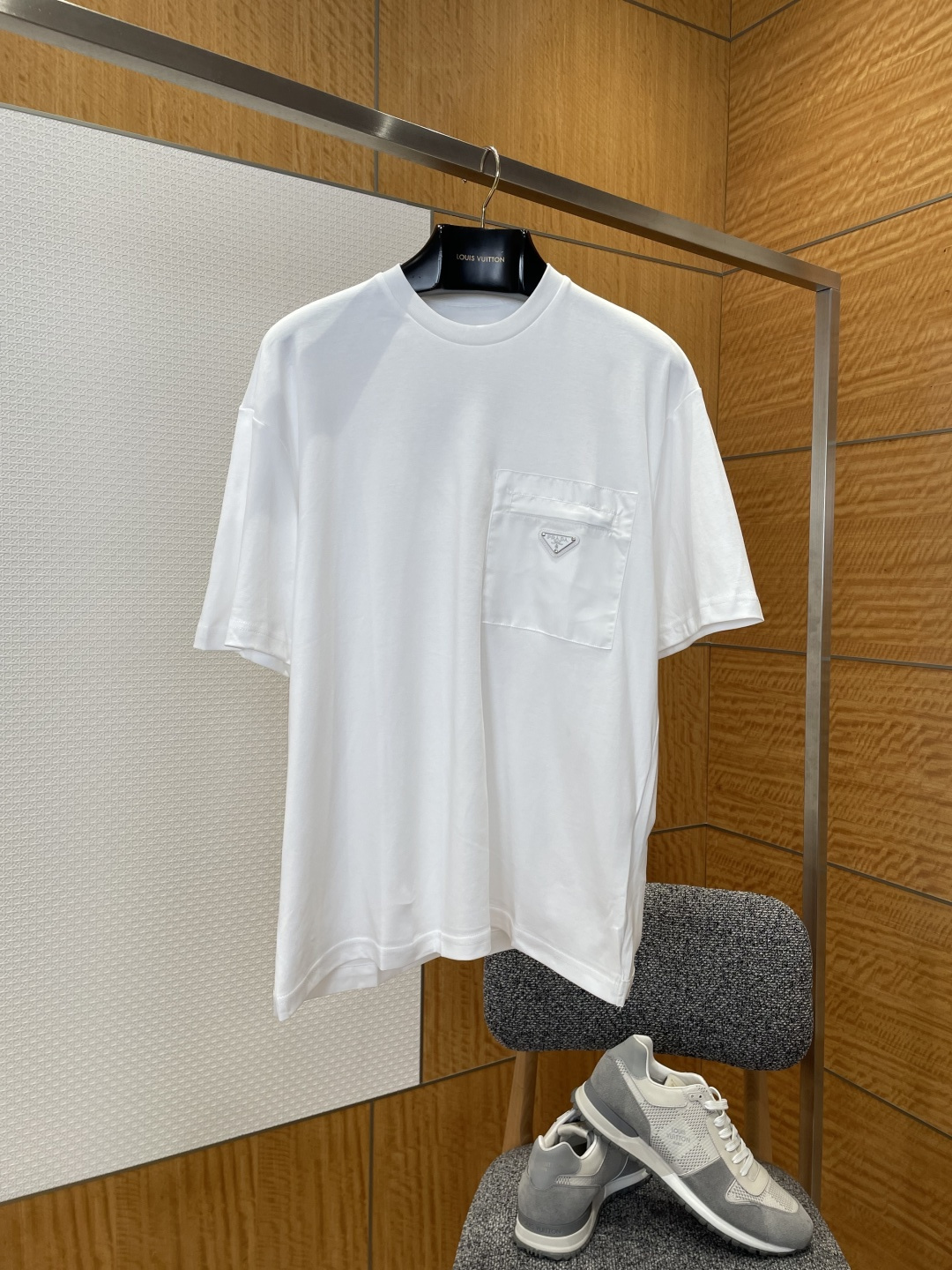 NO:883785,HomeTriangle Logo Pocket Crew Neck Short Sleeve T-Shirt  Made of nylon fabric specially supplied by the brand, the texture is soft and skin-friendly, with a delicate and solid touch. It has good breathability and stiffness, ensuring a comfortable wearing experience and high-end texture. The neckline adopts a classic round neck design, which fits the neck line, neat and elegant, and is suitable for a variety of wearing styles. The three-dimensional triangle logo decoration pocket on the left chest has precise three-dimensional craftsmanship and is also decorated with delicate stitching.  The iconic elements of the original brand break the monotony of solid colors and highlight the brand's recognition and design ingenuity; during the sewing process, the stitches are fine and even, and the pockets and body are connected smoothly and firmly, showing the brand's exquisite craftsmanship. It is a wearable item with both minimalist style and practicality, Prada - clothing, prada, T-shirt, tees, t-shirt,19860909家三角徽标口袋圆领短袖T恤 采用品牌特供尼龙面料,质地柔软亲肤,触感细腻扎实,兼具良好的透气性与挺括度,保证了单品的舒适穿着体验与高级质感；领口采用经典圆领设计,贴合颈部线条,利落大方,适配多种穿搭风格；左胸的立体三角徽标装饰口袋,工艺精密立体,以细腻针脚还原品牌标志性元素,打破纯色单调感,彰显品牌辨识度与设计巧思；缝制过程中,针脚细密均匀,口袋与衣身衔接平整牢固,尽显品牌精湛工艺,是兼具极简格调与实穿性的穿搭单品,普拉达-服装,prada,T-shirt,tees，t-shirt,,Women's clothing