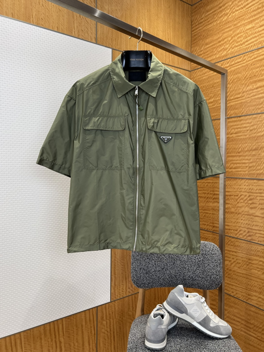 NO:827744,PRA pocket triangle logo short-sleeved lapel jacket ——————  It is made of the brand's iconic regenerated nylon fabric, which has been treated with a special process. It has a light and smooth texture, soft touch, and good breathability and wrinkle resistance, ensuring the quality and practicality of the item; the classic lapel design is matched with a full zipper placket, and the zipper puller is made of resin material of the same color. It opens and closes smoothly, which not only retains the neatness of the shirt, but also adds to the functionality of the jacket; the symmetrical flap large pocket on the chest,  It adopts three-dimensional tailoring, which has both storage function and visual layering. The triangular metal logo inlaid on the right pocket uses enamel technology to highlight the brand identity in a low-key manner. It is a highly recognizable iconic detail. The short-sleeved cut with loose shoulders weakens the formal feeling of traditional shirts and makes it more casual and casual. It is extremely tolerant to all kinds of body shapes. The stitching is fine and even, and the fabric splicing is smooth and firm.  ————————8839088 Material: nylon Loose fit Color military green Size S/M/L/XL, Prada-clothing, prada, prada, jackets & coats, jackets & coats, shirts, T-shirt,19860909PRA口袋三角标短袖翻领夹克外套 ——————— 采用品牌标志性再生尼龙面料,经过特殊工艺处理,质地轻薄顺滑,触感柔软,同时具备良好的透气性与抗皱性,保证了单品的品质与实用性；经典翻领设计搭配全拉链门襟,拉链头采用同色系树脂材质,开合顺滑,既保留了衬衫的利落感,又增添了外套的功能性；胸前对称的翻盖大口袋,采用立体剪裁,兼具收纳功能与视觉层次感,右侧口袋上镶嵌的三角形金属徽标,采用珐琅工艺,低调中彰显品牌身份,是辨识度极高的标志性细节；宽松落肩的短袖剪裁,弱化了传统衬衫的正式感,更显休闲随性,对各类身形都有极佳的包容性；针脚细密均匀,面料拼接处处理得平整牢固. ————————8839088 材质: 尼龙 版型宽松 颜色军绿色 尺码S/M/L/XL,普拉达-服装,prada,prada,jackets & coats,jackets & coats,shirts,T-shirt,,Women's clothing