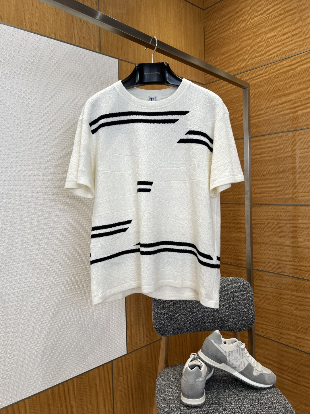 NO:780507,Loewe geometric striped jacquard short-sleeved sweater ——————  It is made of imported high-end wool blended knitted fabric and has undergone a special washing and shaping process. The texture is soft and skin-friendly, fluffy and elastic, and the upper body is light and unburdened. It also has excellent warmth retention and breathability. It can be worn in all seasons, perfectly balancing comfort and style. The body of the garment is designed with a custom-made geometric stripe flocking jacquard, using high-density three-dimensional flocking technology.  The suede is full and fluffy, and the black and white contrasting colors are full of visual impact. The irregular line design breaks the traditional monotony and perfectly integrates the sense of art and high-end. The entire body of the garment is made of three-dimensional jacquard weaving, with clear and delicate texture, and neat and tight routing. The collar, cuffs, and hem are all reinforced with double-strand hemming. Every detail demonstrates the top level of clothing making.  ————————8838088 Material: Wool Loose fit Color black/off-white Size S/M/L/XL, Loewe-clothing, loewe, T-shirt,19860909罗意威几何条纹提花短袖针织衫  ——————— 采用进口高端羊毛混纺针织面料,经过特殊水洗定型工艺,质地软糯亲肤、蓬松有弹性,上身轻盈无负担,同时兼具出色的保暖性与透气性,四季可穿,完美兼顾穿着舒适度与造型感；衣身定制几何条纹植绒提花设计,采用高密立体植绒工艺,绒面饱满蓬松,黑白撞色视觉冲击力拉满,不规则线条设计打破传统单调,将艺术感与高级感完美融合；衣身整体采用立体提花织法,纹理清晰细腻,走线工整严密,领口、袖口、下摆均采用双股线包边加固,每一处细节都彰显顶级制衣水准. ————————8838088 材质: 羊毛 版型宽松 颜色黑色/米白 尺码S/M/L/XL,罗意威-服装,loewe,T-shirt,,Women's clothing