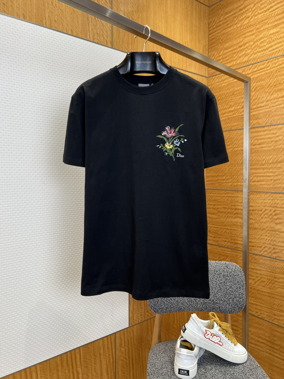 NO:827765,Dior floral embroidered round neck short-sleeved T-shirt ——————  It is made of high-count combed double-ply cotton fabric, which has been treated with pre-shrunk shaping and biological enzyme softening processes. It feels soft and waxy as clouds, has excellent breathability and perspiration performance and a long-lasting anti-wrinkle and drape feeling. It is refreshing and not sweaty when worn daily, and it is not prone to deformation and pilling after long-term washing. The embroidery pattern of the spring bouquet on the chest on the left side of the garment uses high-density three-dimensional embroidery technology, with fine and tight stitching, and natural and soft color transitions.  , vividly restore the smart postures of iris, cornflowers and daisies, paired with the exquisite brand letter logo below, low-key highlighting the brand texture; simple straight and loose version, clean and elegant tailoring, excellent tolerance for different body shapes, casual and lazy upper body, easy to create a variety of styles; double seam stitching technology to strengthen the hem and cuffs, the details show the brand's ingenuity and quality.  ————————8825088 Material: Cotton Loose fit Color black/white Size XS/S/M/L, Dior-clothing, dior, T-shirt, tees, t-shirt,19860909迪奥花卉刺绣圆领短袖T恤 ——————— 采用高支精梳双股棉面料,经过预缩定型与生物酶柔化工艺处理,触感软糯如云,兼具优越的透气排汗性能与持久抗皱垂坠感,日常穿着清爽不闷汗,久洗也不易变形起球；衣身左侧胸口的春日花束刺绣图案,采用高密度立体刺绣工艺,针脚细腻紧密,色彩过渡自然柔和,将鸢尾、矢车菊与雏菊的灵动姿态生动还原,搭配下方精致的品牌字母标识,低调彰显品牌质感；简约直筒宽松版型,剪裁利落大气,对不同身形都有着极佳的包容度,上身随性慵懒,轻松打造多种风格穿搭；双车线锁边工艺加固衣摆与袖口,细节处尽显品牌匠心品质. ————————8825088 材质: 棉 版型宽松 颜色黑色/白色 尺码XS/S/M/L,迪奥-服装,dior,T-shirt,tees，t-shirt,,Women's clothing