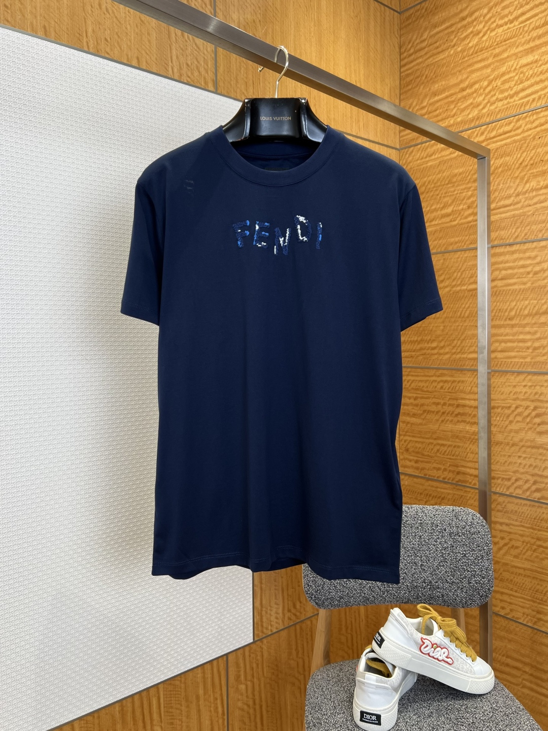 NO:825946,FENDI Fendi gradient embroidered letter short-sleeved T-shirt ————————  It is made of imported high-count combed cotton fabric, which has been processed by pre-shrunk washing process. It feels soft and skin-friendly, breathable and dry to wear, and is not easy to wrinkle and deform. It still maintains a smooth and crisp texture after multiple washings. The classic round neck type adopts high-density thread binding technology, which makes the collar not easy to loose and deform after long-term wear. It fits the neck line, is simple and elegant, and is not picky in style. The FENDI letter logo on the front of the body is made of high-density three-dimensional embroidery.  The embroidery process creates a gradient effect, the stitching is delicate and neat, and the color transition is natural. The different color matching versions cleverly echo the background color of the body, highlighting the brand recognition in a low-key manner, breaking the monotony of the basic style; the cuffs and hem adopt double-line precision seaming technology, which is solid and flat, comfortable to wear and does not rub the skin, and the details show high-end quality; the overall design is simple and elegant, with both daily wearability and the brand's iconic design language.  ————————8825088 Material: cotton, loose fit, color white/navy, size XS/S/M/L, Fendi-clothing, fendi, fendi, T-shirt, tees, t-shirt,19860909FENDI芬迪渐变刺绣字母短袖T恤 ———————— 采用进口高支精梳纯棉面料,经过预缩水洗工艺处理,触感软糯亲肤,穿着透气干爽,不易起皱变形,多次洗涤依旧保持平整挺括的质感；经典圆领领型采用高密度螺纹包边工艺,领口久穿不易松垮变形,贴合颈部线条,简约大气不挑穿搭风格；衣身正面的FENDI字母标识,采用高密立体刺绣工艺打造渐变效果,针脚细腻工整,色彩过渡自然,不同配色版本与衣身底色巧妙呼应,低调中彰显品牌辨识度,打破基础款的单调感；袖口与下摆采用双线精密锁边工艺,做工扎实平整,穿着舒适不磨皮肤,细节处尽显高端品质；整体设计简约大气,兼具日常实穿性与品牌标志性设计语言. ————————8825088 材质: 棉 版型宽松 颜色白色/藏青 尺码XS/S/M/L,芬迪-服装,fendi,fendi,T-shirt,tees，t-shirt,,Women's clothing