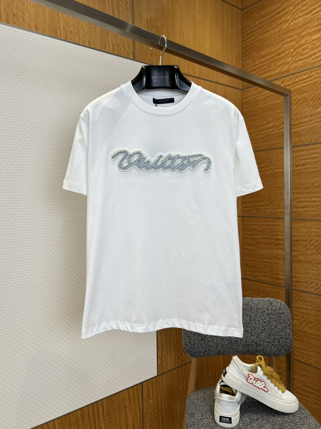 NO:827716,1V flocked embroidered letters short-sleeved T-shirt ————————  Made of brand-customized high-count combed cotton fabric, the texture is fine and soft, with excellent breathability and drape. It feels smooth against the skin and is not easily wrinkled or deformed at the back, ensuring the high-end texture and wearing experience of the T-shirt. The neckline adopts a classic round neck design, with reinforced ribbing technology, which is not easy to deform and loose, and fits the neck line, making it comfortable and durable to wear. The front of the shirt is decorated with the brand's iconic flocked embroidered letter logo.  , using a combination of difficult flocking and embroidery technology, the rough flocking texture on the edge of the letters is fluffy and three-dimensional, the embroidery stitches are even and smooth, and the color transition is natural and delicate, breaking the monotony of the solid color T-shirt and adding a unique artistic atmosphere and recognition to the overall shape; the entire T-shirt has rigorous and delicate thread routing technology, even stitching, and every detail from the collar to the hem reflects the brand's strict control of quality.  ————————8825088 Material: cotton, loose fit, color off-white/black, size S/M/L/XL, Louis Vuitton-clothing, Louis Vuitton, T-shirt, tees, t-shirt,198609091V植绒刺绣字母短袖T恤 ———————— 采用品牌定制高支精梳棉面料,质地细腻软糯,兼具出色的透气性与垂坠感,触感亲肤顺滑,上身后不易起皱变形,保障了T恤的高级质感与穿着体验；领口采用经典圆领设计,搭配加固罗纹包边工艺,不易变形松垮,贴合颈部线条,穿着舒适且耐穿；衣身正面饰有品牌标志性的植绒刺绣字母标识,采用高难度植绒与刺绣结合工艺,字母边缘的毛边植绒质感蓬松立体,刺绣针脚均匀平整,色彩过渡自然细腻,打破了纯色T恤的单调感,为整体造型增添了独特的艺术氛围与辨识度；整件T恤的走线工艺严谨细腻,针脚均匀平整,从领口到衣摆的每一处细节,均体现出品牌对品质的严苛把控. ————————8825088 材质: 棉 版型宽松 颜色米白/黑色 尺码S/M/L/XL,路易威登-服装,louis vuitton,T-shirt,tees，t-shirt,,Women's clothing