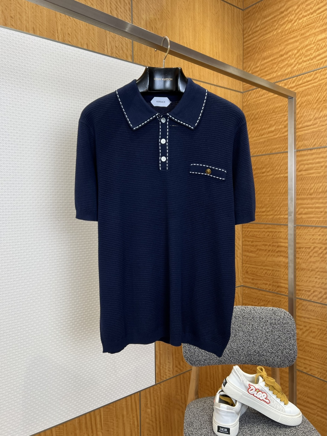 NO:827754,VS open-stitched knitted POLO shirt ————————  Made of customized high-count knitted fabric, the texture is soft and skin-friendly, with a delicate and smooth touch. It has excellent breathability and drape. The upper body is light and pressure-free, and will not easily deform and pill after long-term wear. The body of the garment is made of exquisite waffle texture technology, with a delicate and three-dimensional texture, and a soft and high-end texture that appears under the light.  It gives off a low-key luster; the collar and placket are decorated with contrasting topstitching, the stitching is fine and even, and the stitching is neat and smooth, breaking the monotony of solid colors and adding a sense of retro detailed design; the cuffs and hem are made of plain weave trimming technology, with smooth and neat edges, making it comfortable to wear without being tight; it has a loose and neat fit.  ————————8842088 Material High count knitted fabric Loose fit Color brown/navy blue Size S/M/L/XL, Versace-clothing,versace,19860909VS明线装饰针织POLO衫 ———————— 采用定制高支针织面料,质地软糯亲肤,触感细腻顺滑,兼具出色透气性与垂坠感,上身轻盈无压,久穿不易变形起球；衣身采用精致华夫格织纹工艺,肌理细腻立体,自带柔光高级质感,在光线下呈现出低调的光泽感；领口与门襟采用撞色明线装饰,针脚细密均匀,走线工整流畅,打破纯色单调感,增添复古细节设计感；袖口与下摆采用平纹收边工艺,边缘平整利落,穿着舒适不勒身；宽松利落版型. ————————8842088 材质高支针织面料 版型宽松 颜色棕色/藏青色 尺码S/M/L/XL,范思哲-服装,versace,,Women's clothing