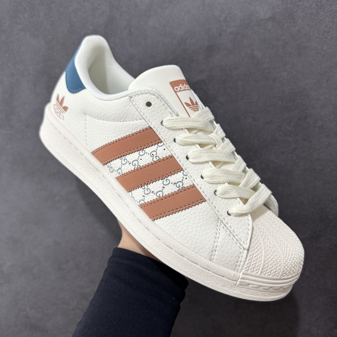 图片[3]-【定制版】Gucci x Adidas Original Superstar 古驰古奇 x 阿迪达斯 低帮 联名白棕蓝 贝壳头防滑耐磨轻便板鞋 鞋身整体采用米白色皮革打造，搭配经典米白贝壳头，鞋身两侧经典锯齿三条杠Logo采用棕色3M反光材质点缀，侧身点缀蓝色Superstar字样，鞋舌上以棕色Adidas字样及三叶草Logo呈现，瞬间提升鞋子的时尚程度，后跟装饰片辅以蓝色3M反光材质制作并带有白色Adidas字样及三叶草LLogo，后跟印有Gucci字样，彰显联名身份，最后以米白色中底搭配同色橡胶外底完善整体设计收尾。 货号：SD6817 尺码：36-45半-选品中心