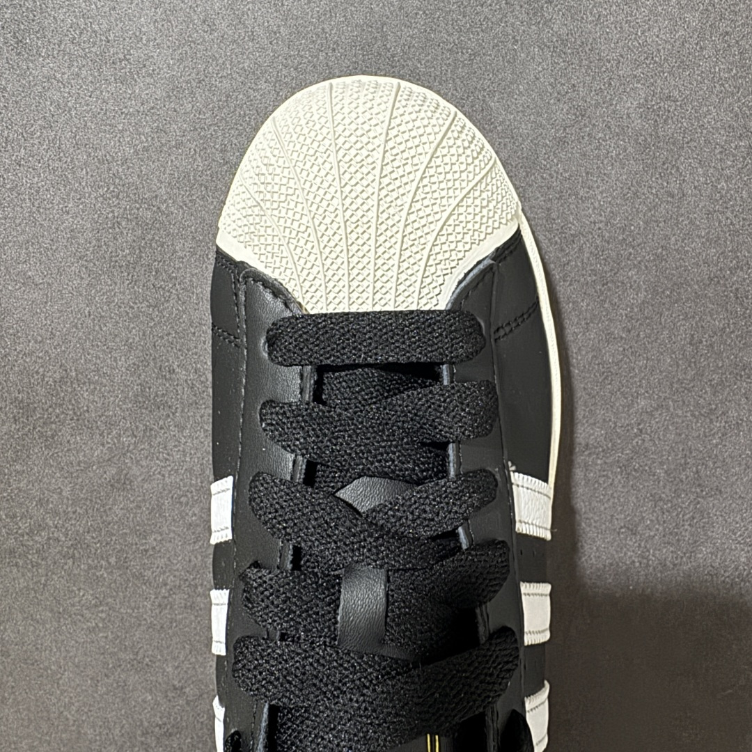 图片[5]-【公司级】Adidas Original Superstar 2 阿迪达斯 低帮 男女同款 贝壳头2代防滑耐磨轻便低邦板鞋 鞋身整体以黑色皮革打造，搭配经典白色贝壳头，鞋身两侧经典锯齿三条杠Logo采用白色点缀，侧身Superstar字样金色压印妆点，鞋舌黑色底色上压印金色品牌大logo，后跟装饰片同样烫印金色logo，最后以白色大底完善整体设计收尾。整体大方耐看。 货号：KI0981 尺码：35¹/₃ 36 36²/₃ 37¹/₃ 38 38²/₃ 39¹/₃ 40 40²/₃ 41¹/₃ 42 42²/₃ 43¹/₃ 44 44²/₃ 45¹/₃-选品中心