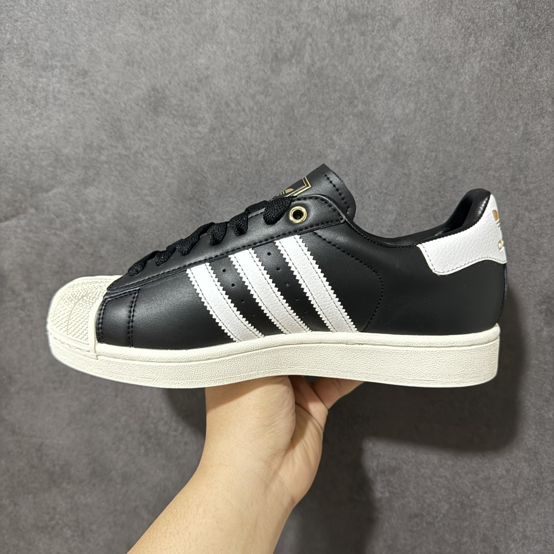 图片[2]-【公司级】Adidas Original Superstar 2 阿迪达斯 低帮 男女同款 贝壳头2代防滑耐磨轻便低邦板鞋 鞋身整体以黑色皮革打造，搭配经典白色贝壳头，鞋身两侧经典锯齿三条杠Logo采用白色点缀，侧身Superstar字样金色压印妆点，鞋舌黑色底色上压印金色品牌大logo，后跟装饰片同样烫印金色logo，最后以白色大底完善整体设计收尾。整体大方耐看。 货号：KI0981 尺码：35¹/₃ 36 36²/₃ 37¹/₃ 38 38²/₃ 39¹/₃ 40 40²/₃ 41¹/₃ 42 42²/₃ 43¹/₃ 44 44²/₃ 45¹/₃-选品中心