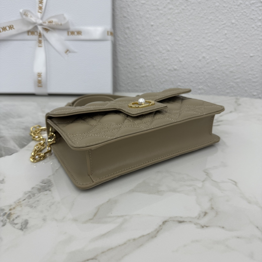 这款 Dior Jolie 迷你链条手袋是二零二五秋冬成衣系列新品，兼具优雅气质与实用功能。采用奶茶杏羊皮革精心制作，搭配藤格纹缉面线，翻盖饰以点缀白色树脂珠饰的复古金色饰面金属CD 标志。内设一个隔层，可收纳各种用品。搭配可调节、可拆卸CD链环肩带，穿插点缀以白色树脂珠饰，饰以皮革带，可搭配日常造型或晚装舒适手提、肩背或斜挎。 
主体:羊皮革 
里料:羊皮革，科技面料 正面CD 扣环饰以白色树脂珠饰翻盖开合内部插袋6 个卡槽 饰以树脂珠饰和皮革带的可调节、可拆卸链条肩带内含防尘袋意大利制造 
尺寸：21cm×11.5cm×4.5cm 
编号：S3117