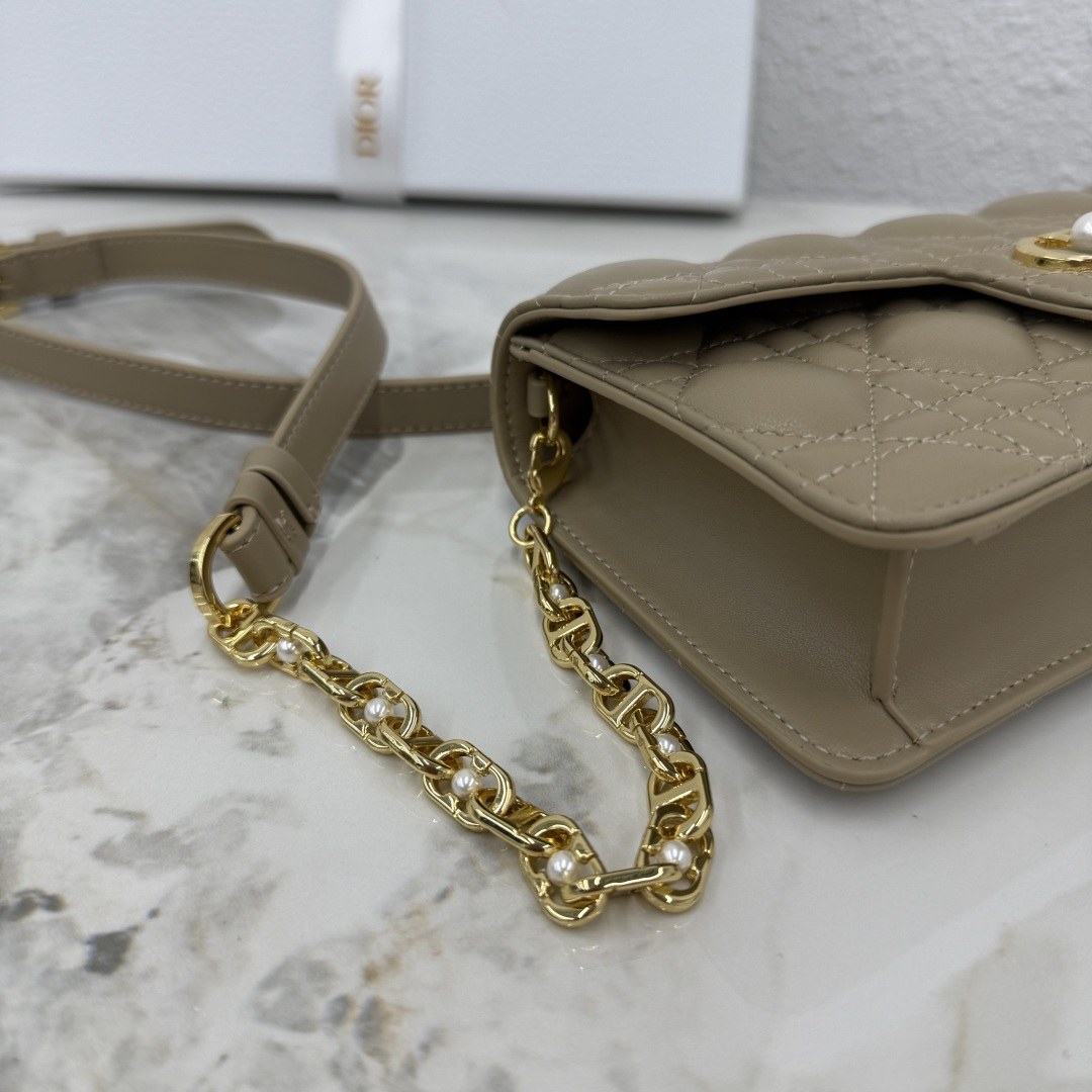 这款 Dior Jolie 迷你链条手袋是二零二五秋冬成衣系列新品，兼具优雅气质与实用功能。采用奶茶杏羊皮革精心制作，搭配藤格纹缉面线，翻盖饰以点缀白色树脂珠饰的复古金色饰面金属CD 标志。内设一个隔层，可收纳各种用品。搭配可调节、可拆卸CD链环肩带，穿插点缀以白色树脂珠饰，饰以皮革带，可搭配日常造型或晚装舒适手提、肩背或斜挎。 
主体:羊皮革 
里料:羊皮革，科技面料 正面CD 扣环饰以白色树脂珠饰翻盖开合内部插袋6 个卡槽 饰以树脂珠饰和皮革带的可调节、可拆卸链条肩带内含防尘袋意大利制造 
尺寸：21cm×11.5cm×4.5cm 
编号：S3117