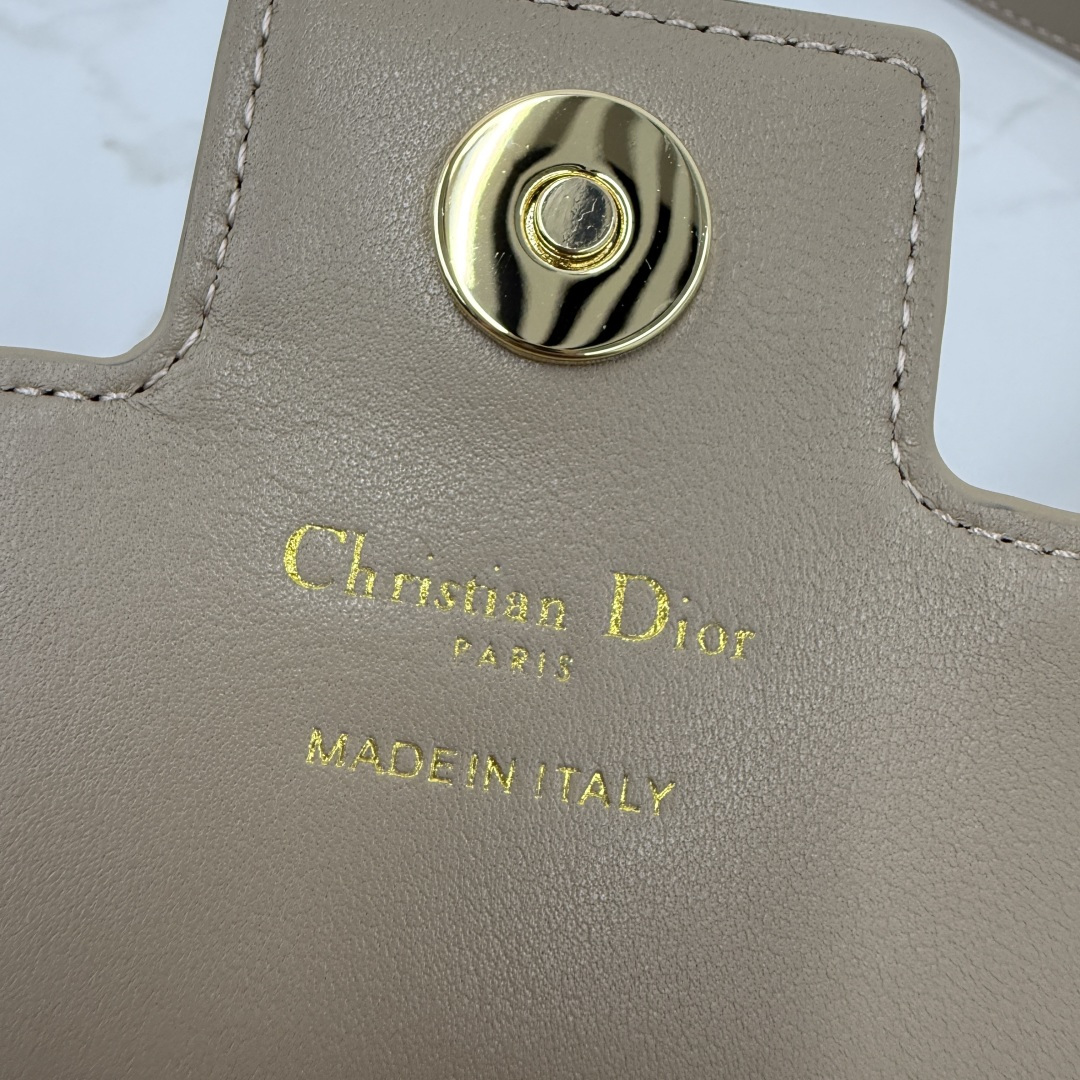 这款 Dior Jolie 迷你链条手袋是二零二五秋冬成衣系列新品，兼具优雅气质与实用功能。采用奶茶杏羊皮革精心制作，搭配藤格纹缉面线，翻盖饰以点缀白色树脂珠饰的复古金色饰面金属CD 标志。内设一个隔层，可收纳各种用品。搭配可调节、可拆卸CD链环肩带，穿插点缀以白色树脂珠饰，饰以皮革带，可搭配日常造型或晚装舒适手提、肩背或斜挎。 
主体:羊皮革 
里料:羊皮革，科技面料 正面CD 扣环饰以白色树脂珠饰翻盖开合内部插袋6 个卡槽 饰以树脂珠饰和皮革带的可调节、可拆卸链条肩带内含防尘袋意大利制造 
尺寸：21cm×11.5cm×4.5cm 
编号：S3117